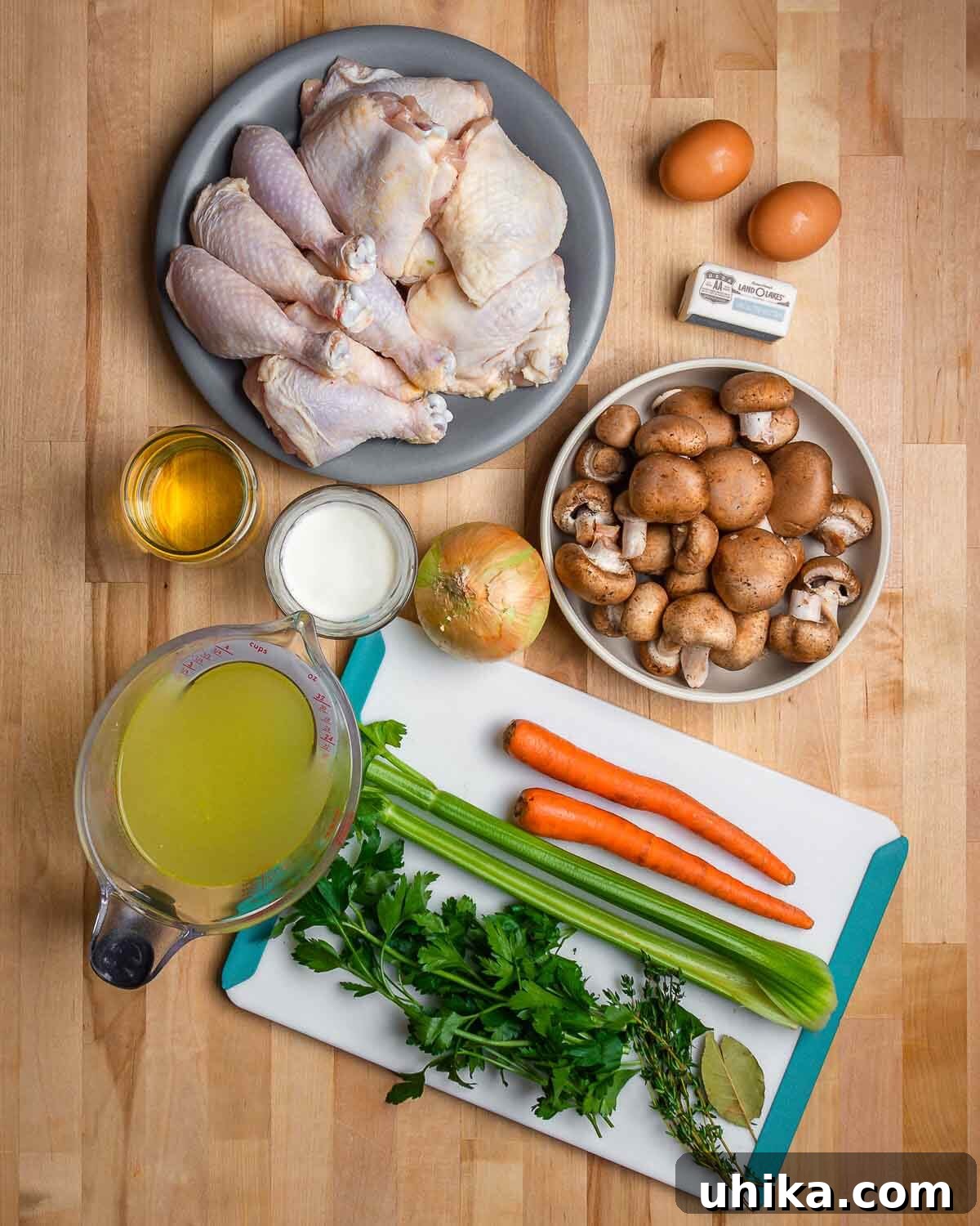 Velvety French Chicken Stew 3 Overhead shot of chicken fricassee recipe ingrdients. Fresh ingredients laid out including chicken, carrots, celery, mushrooms, and herbs.