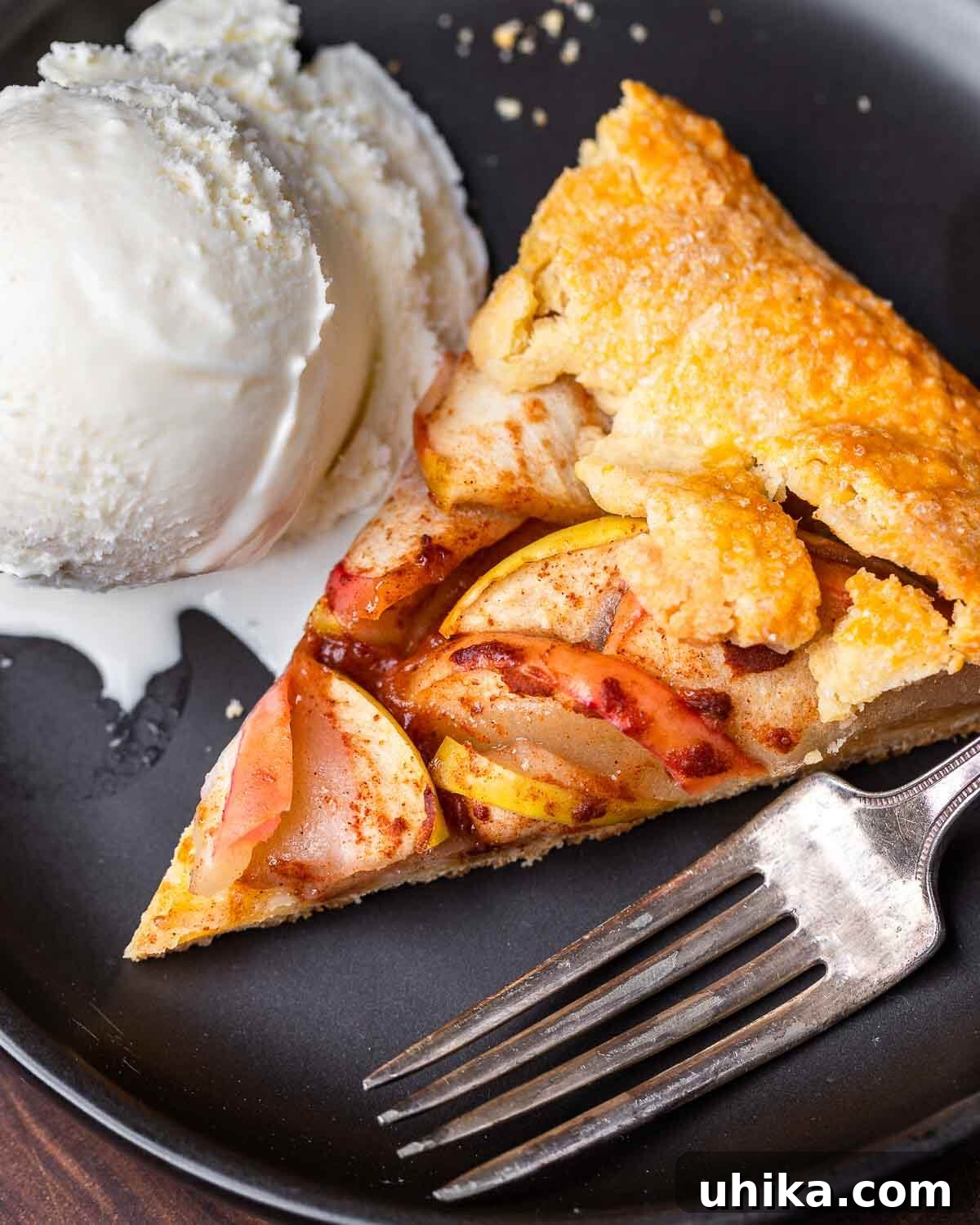 Rustic Apple Galette 2 Slice of apple crostata and vanilla ice cream on black plate.