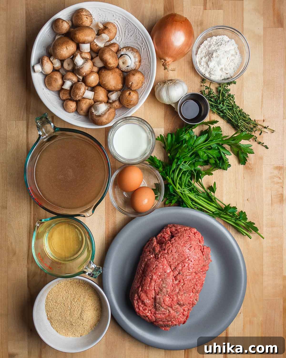 Ultimate Comfort Meatloaf with Rich Gravy 3 Ingredients for meatloaf with brown gravy, including mushrooms, onion, flour, garlic, Worcestershire sauce, thyme, parsley, beef stock, milk, eggs, white wine, breadcrumbs, and ground beef.