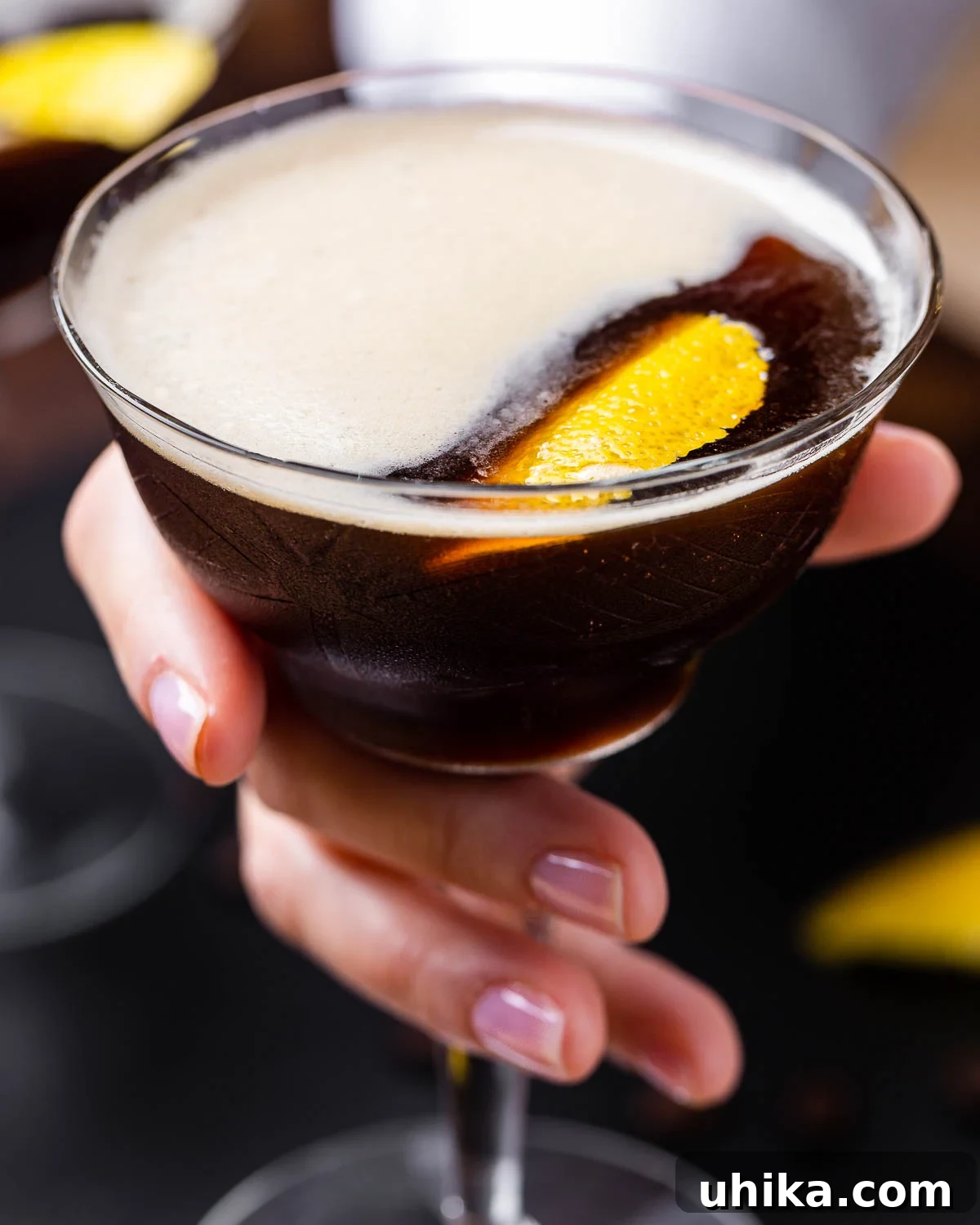 Velvet Nightcap 2 Hand holding an elegant espresso martini in a coupe glass.