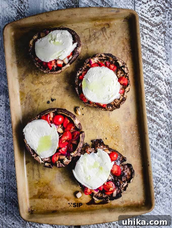 Portobello mushrooms topped with mozzarella. Portobello mushrooms, stuffed with bruschetta, now topped with fresh mozzarella slices.