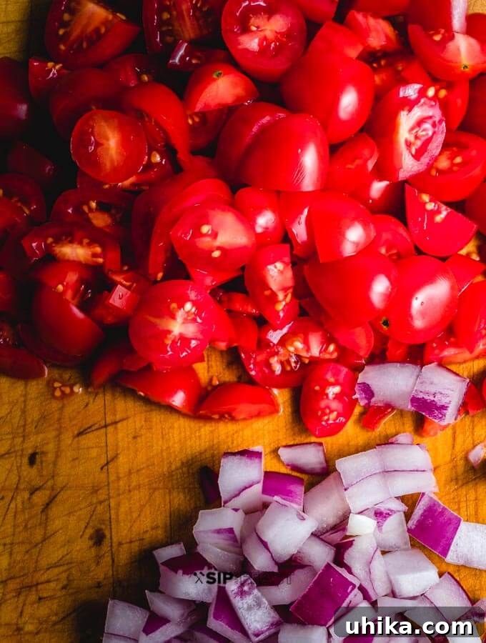 Bruschetta ingredients chopped and ready. Finely chopped cherry tomatoes and diced red onions, prepared for the bruschetta mixture.