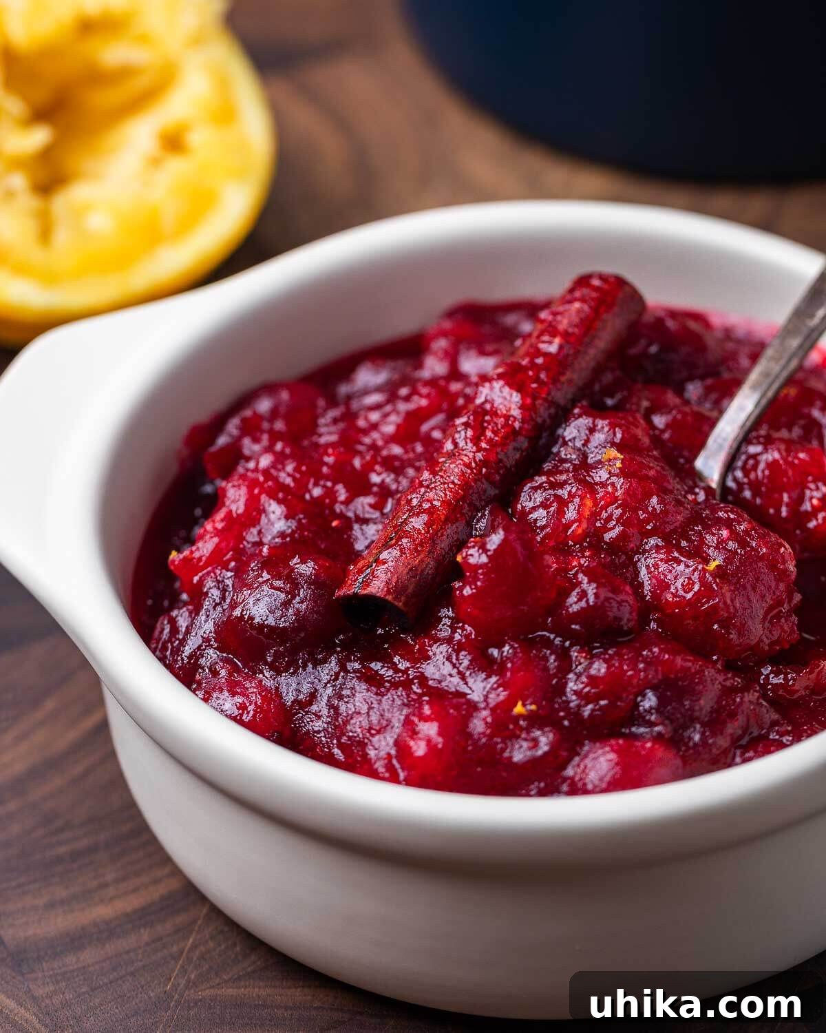 Ruby Red Cranberry Zing 2 Cranberry sauce in white bowl with squeezed orange in background, ready for serving.