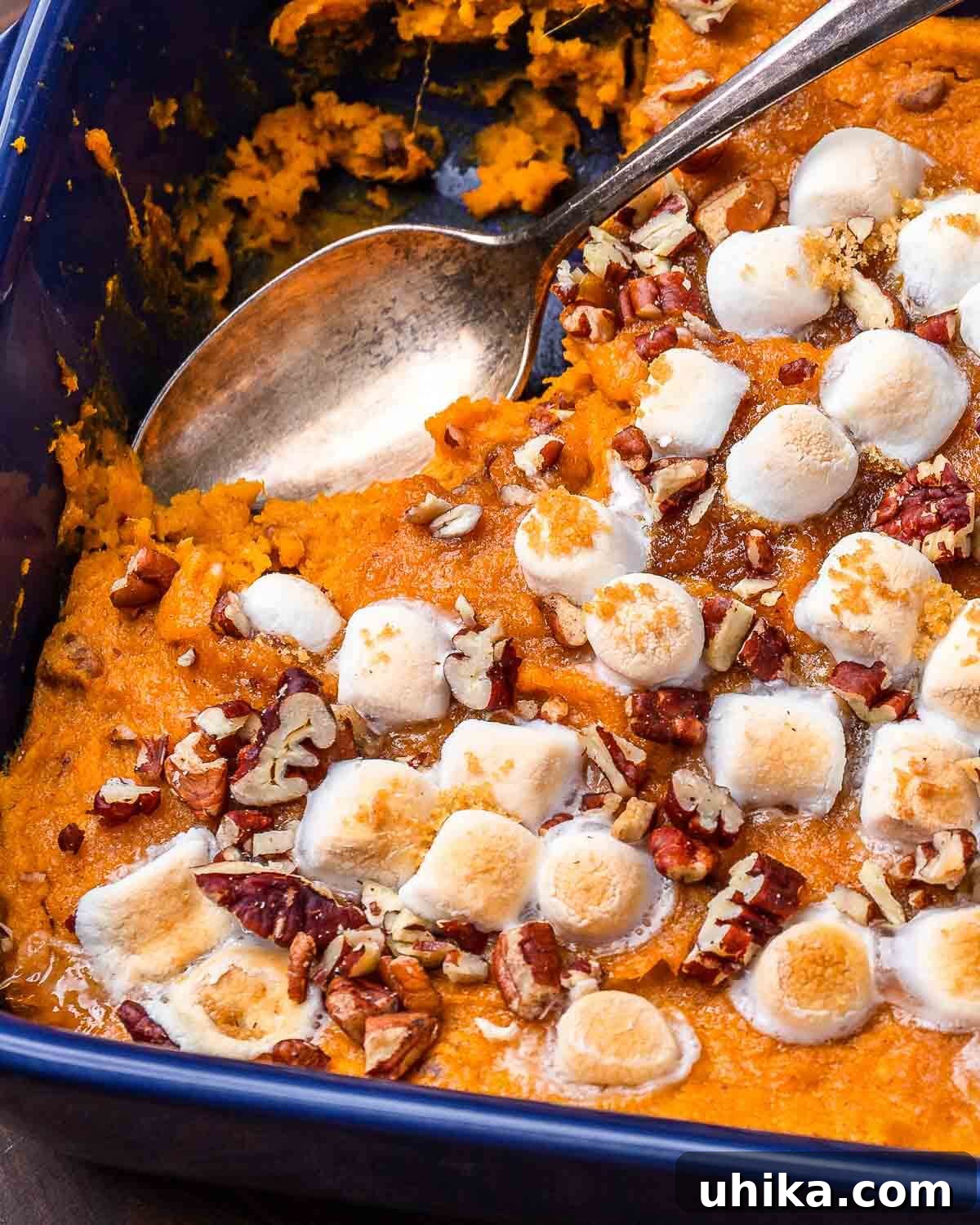 Sweet Potato Cloud with Pecan Crunch 8 Closeup shot of sweet potato casserole in baking dish with a spoonful removed.
