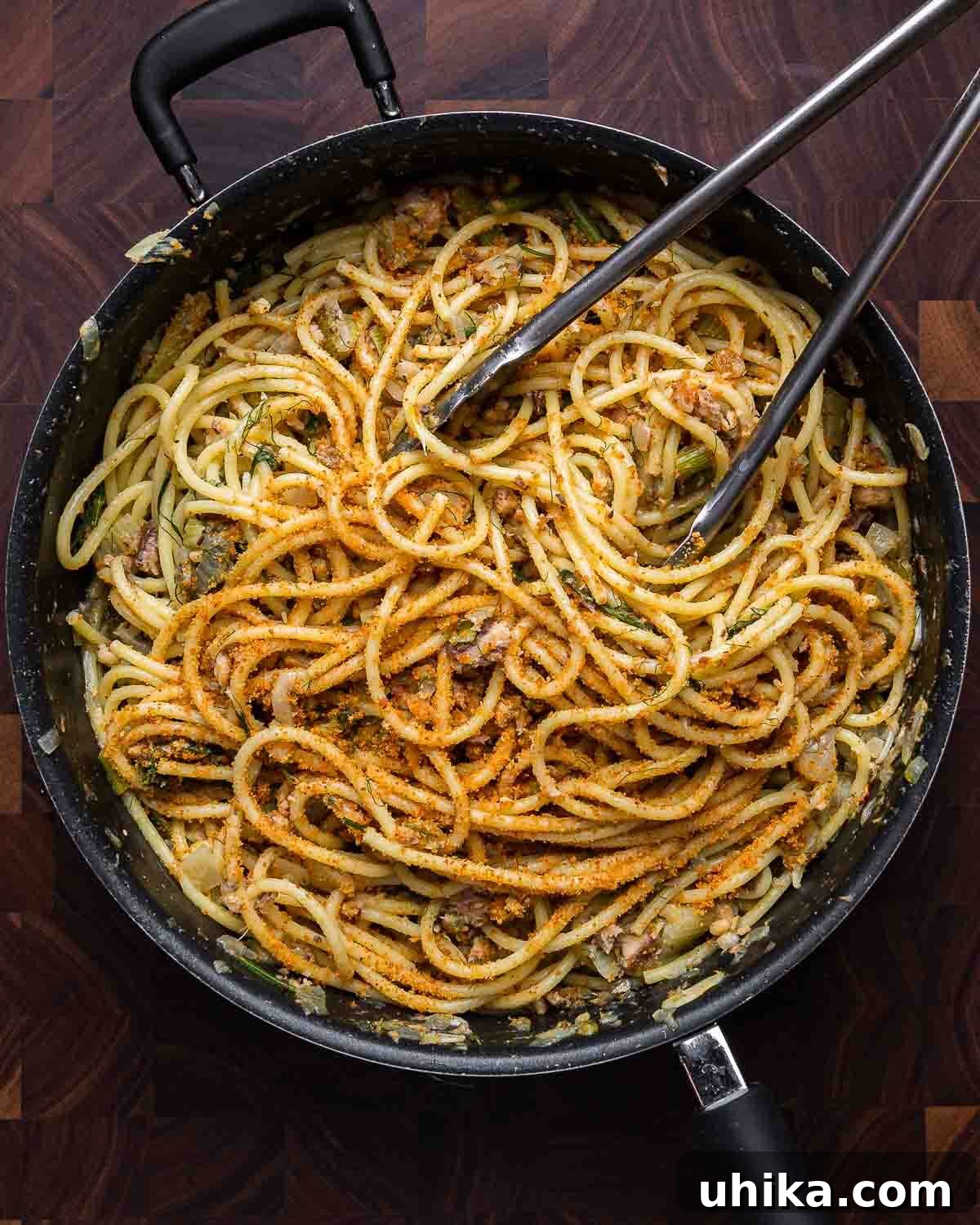 Sicilian Sardine Pasta 4 Close-up shot of the finished Pasta con le Sarde in a black pan on a wooden cutting board.