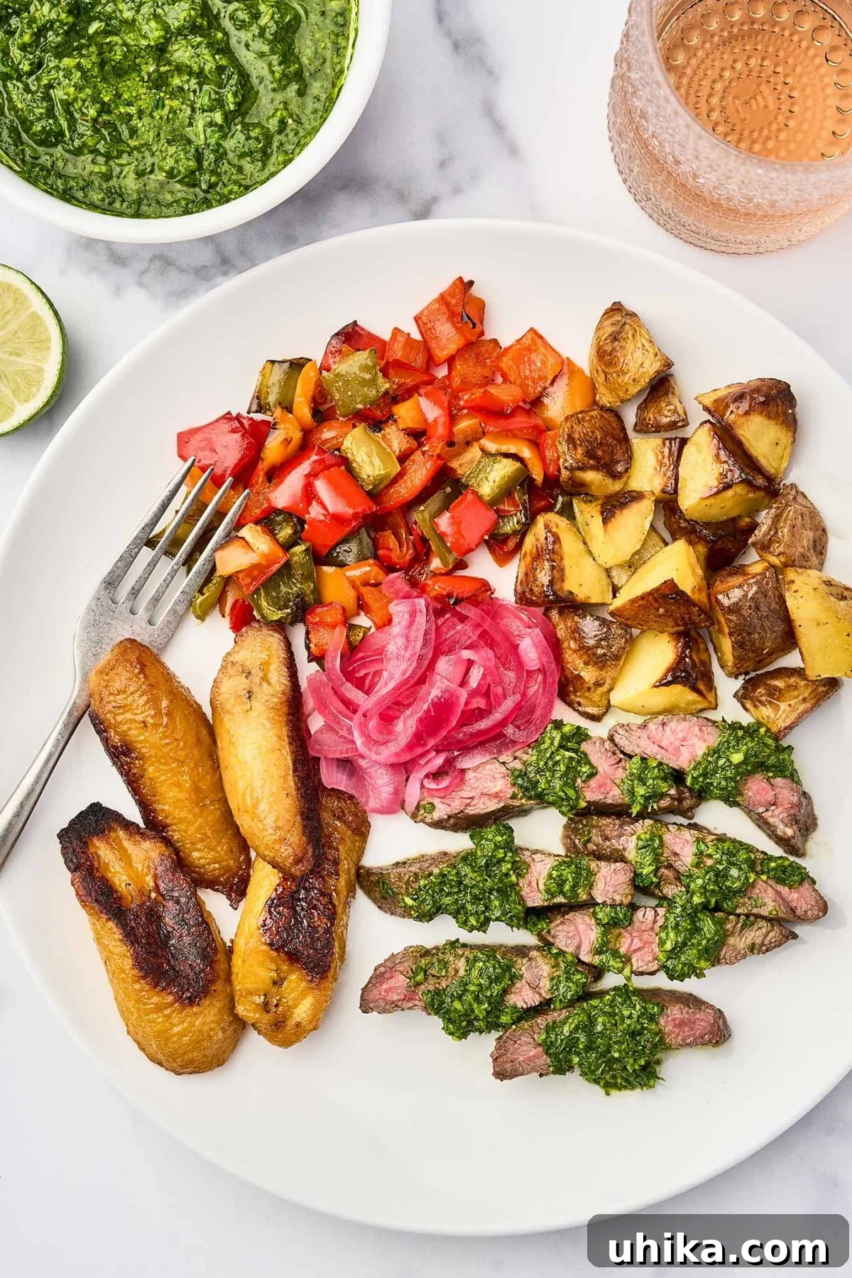 Sizzling Steak, Vibrant Chimichurri 6 A plate of grilled skirt steak with chimichurri sauce, served with roasted sweet plantains, pickled red onions, roasted potatoes, and sautéed bell peppers.