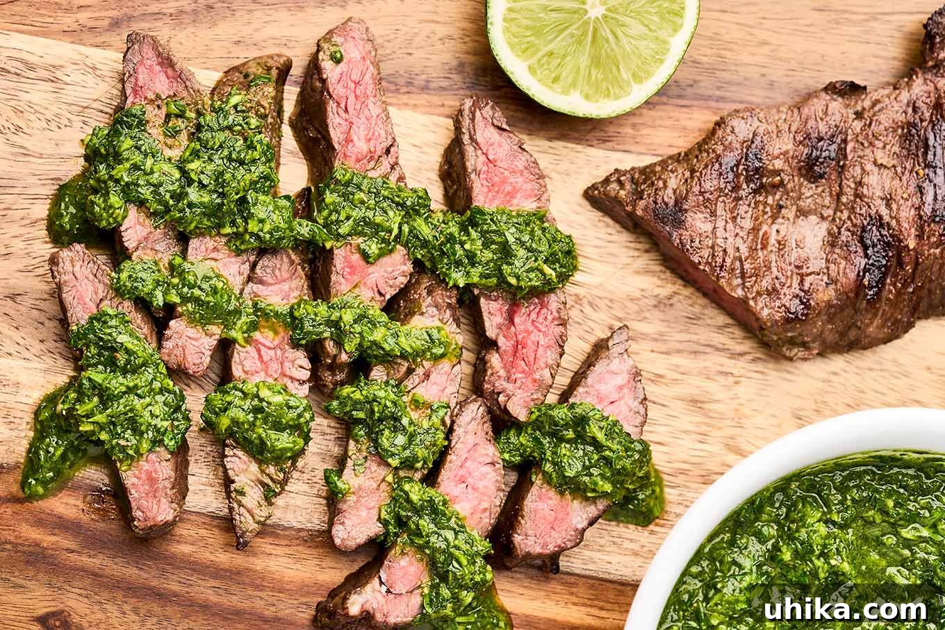 Sizzling Steak, Vibrant Chimichurri 7 Sliced grilled skirt steak drizzled with vibrant green chimichurri sauce on a wooden cutting board, served with fresh lime.
