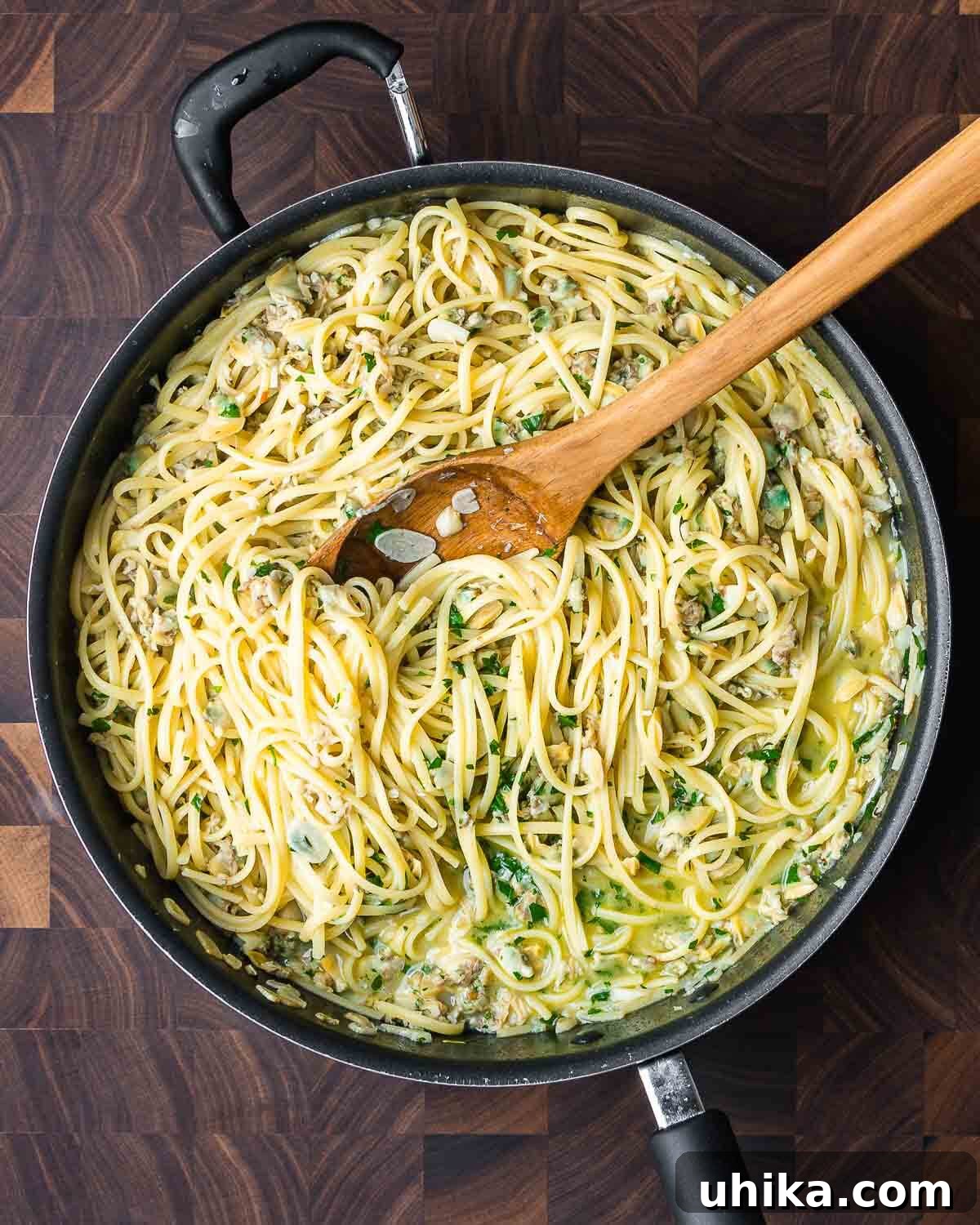 Easy Weeknight Clam Linguine 11 Overhead shot of Linguine with canned clam sauce in large black pan on cutting board.