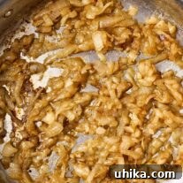 A stainless steel skillet filled with perfectly caramelized onions, ready to be served or incorporated into other dishes.