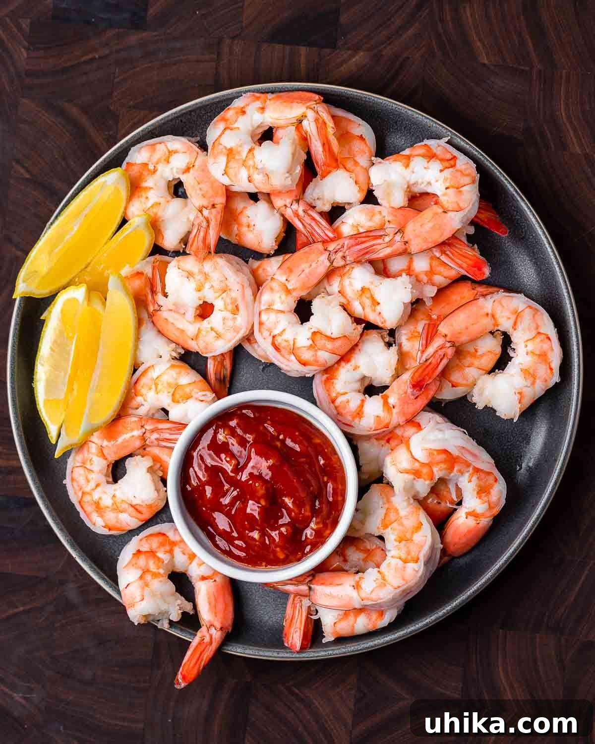 Chilled Prawn Perfection 7 Overhead shot of large plate of shrimp cocktail with cocktail sauce and lemons.