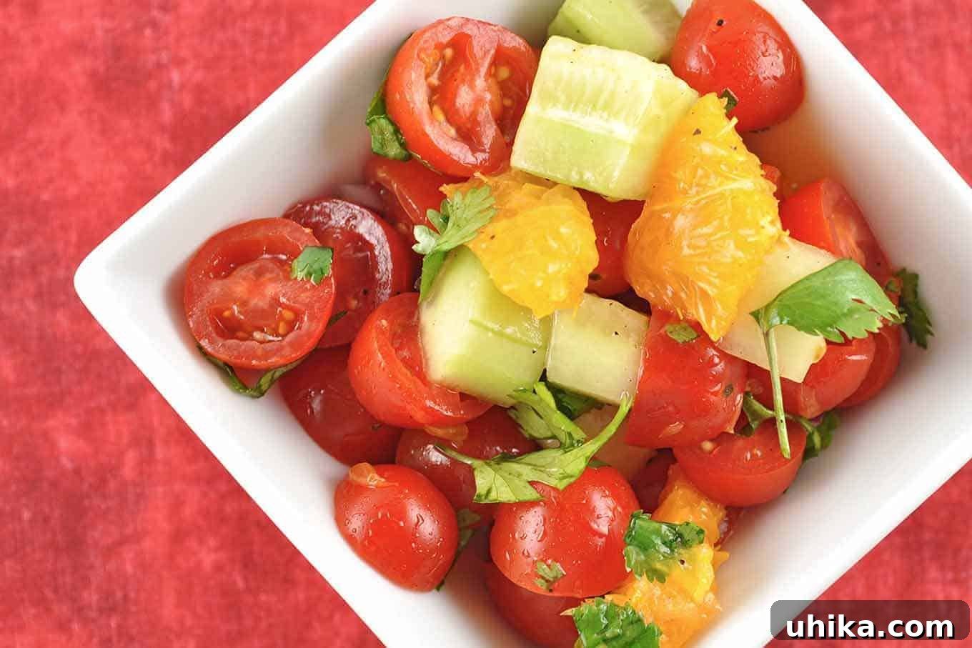 Vibrant Tomato Orange Cucumber Salad 2 Vibrant Tomato, Orange, and Cucumber Salad glistening with a light dressing, ready to be served.