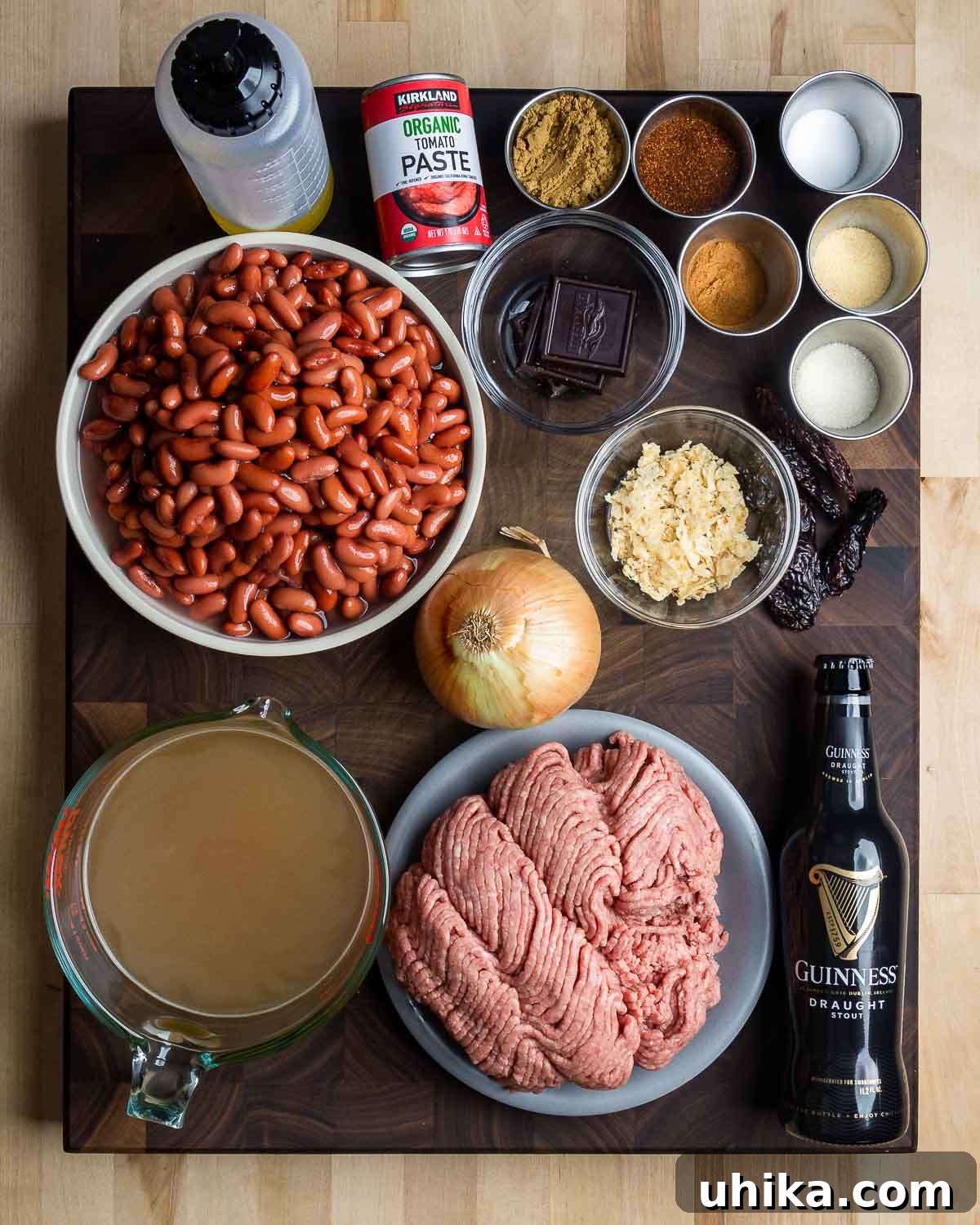 Hearty Classic Chili 3 Ingredients shown: vegetable oil, tomato paste, dark chocolate, chile powder and spices, whole dried chiles, kidney beans, onion, tortilla chips, beef stock, ground chuck, and beer.