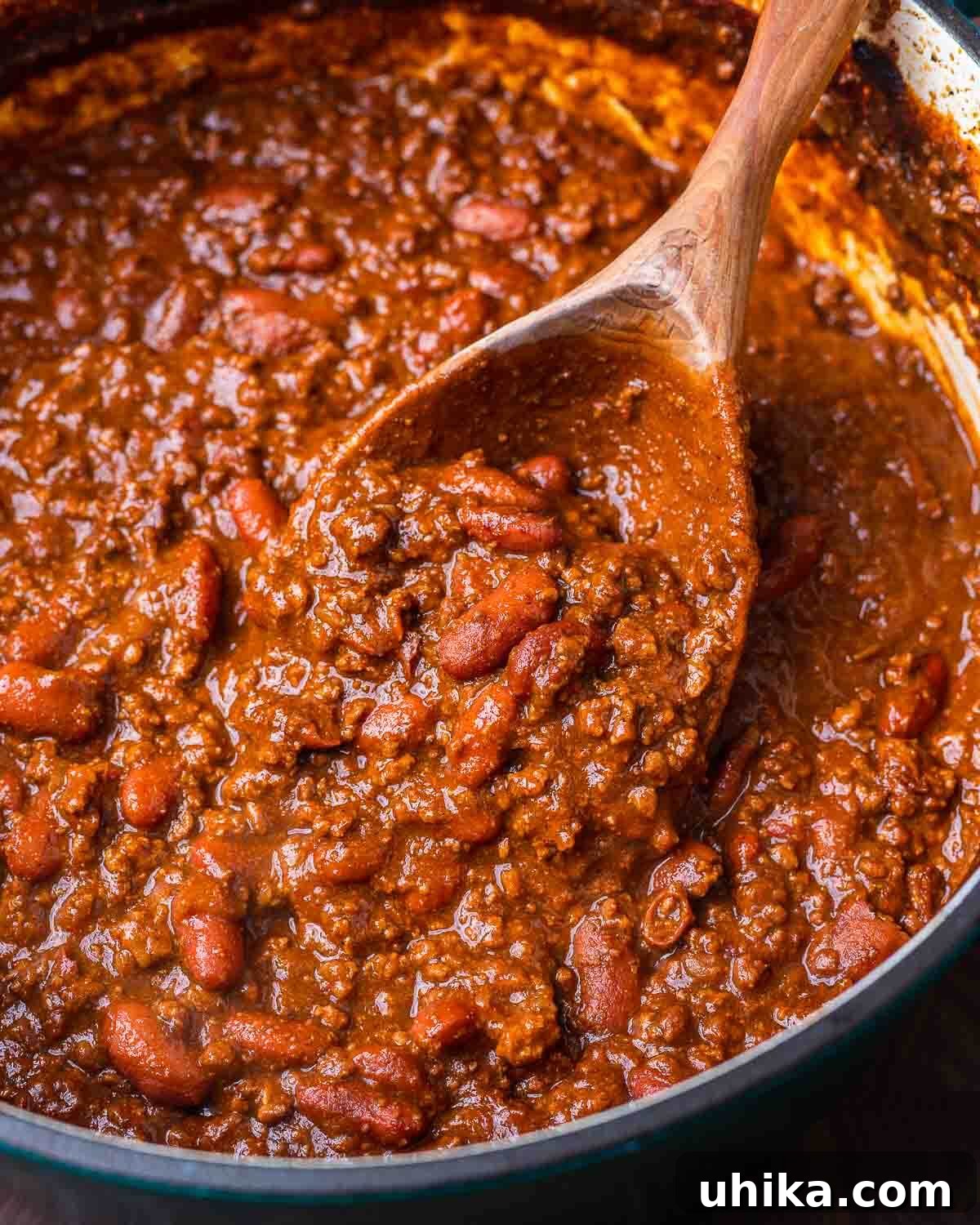 Hearty Classic Chili 7 Large Dutch oven with classic chili and large wooden ladle.