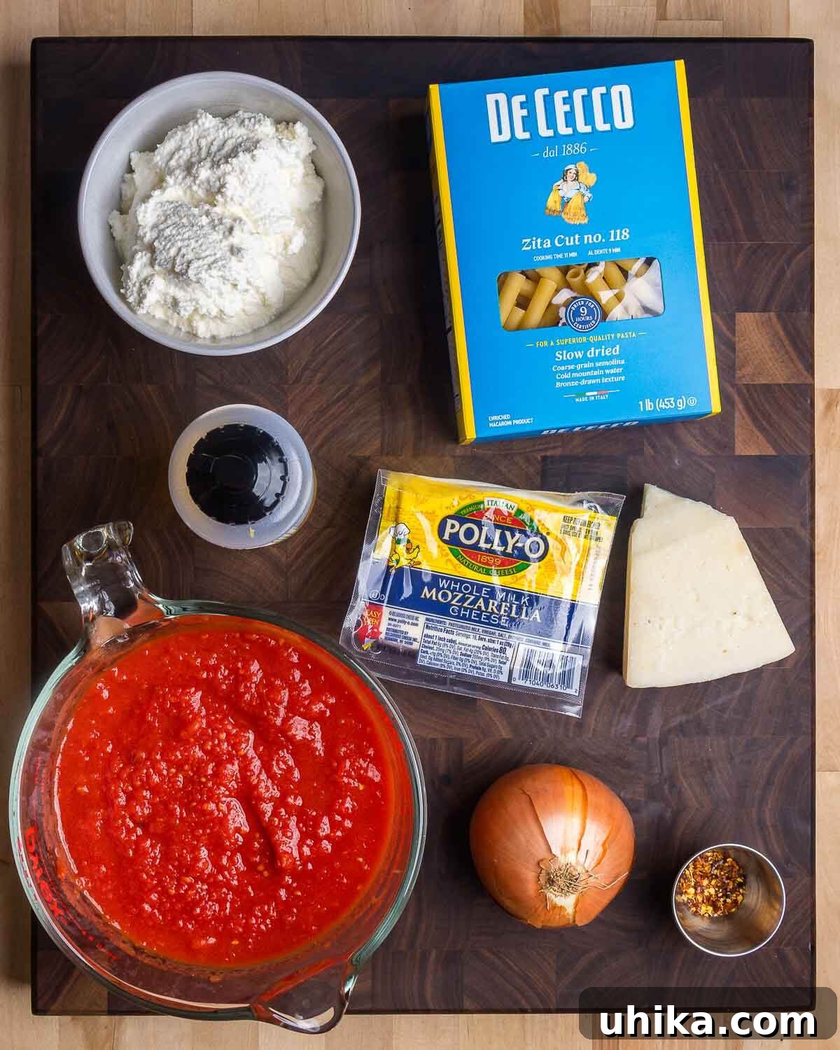 Cheesy Meatball Ziti Bake 4 A collection of ingredients for the baked ziti: creamy ricotta, ziti pasta, olive oil, shredded mozzarella, grated Pecorino, rich tomato sauce, diced onion, and a pinch of red pepper flakes.