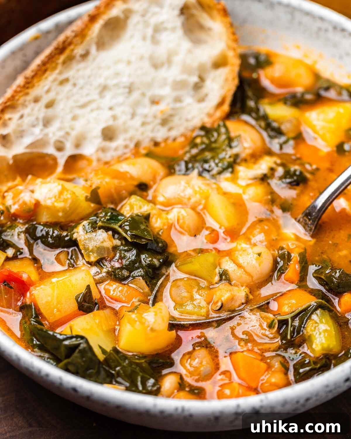 Hearty Vegetable Minestrone 2 Large white bowl of minestrone soup with spoon and piece of bread.