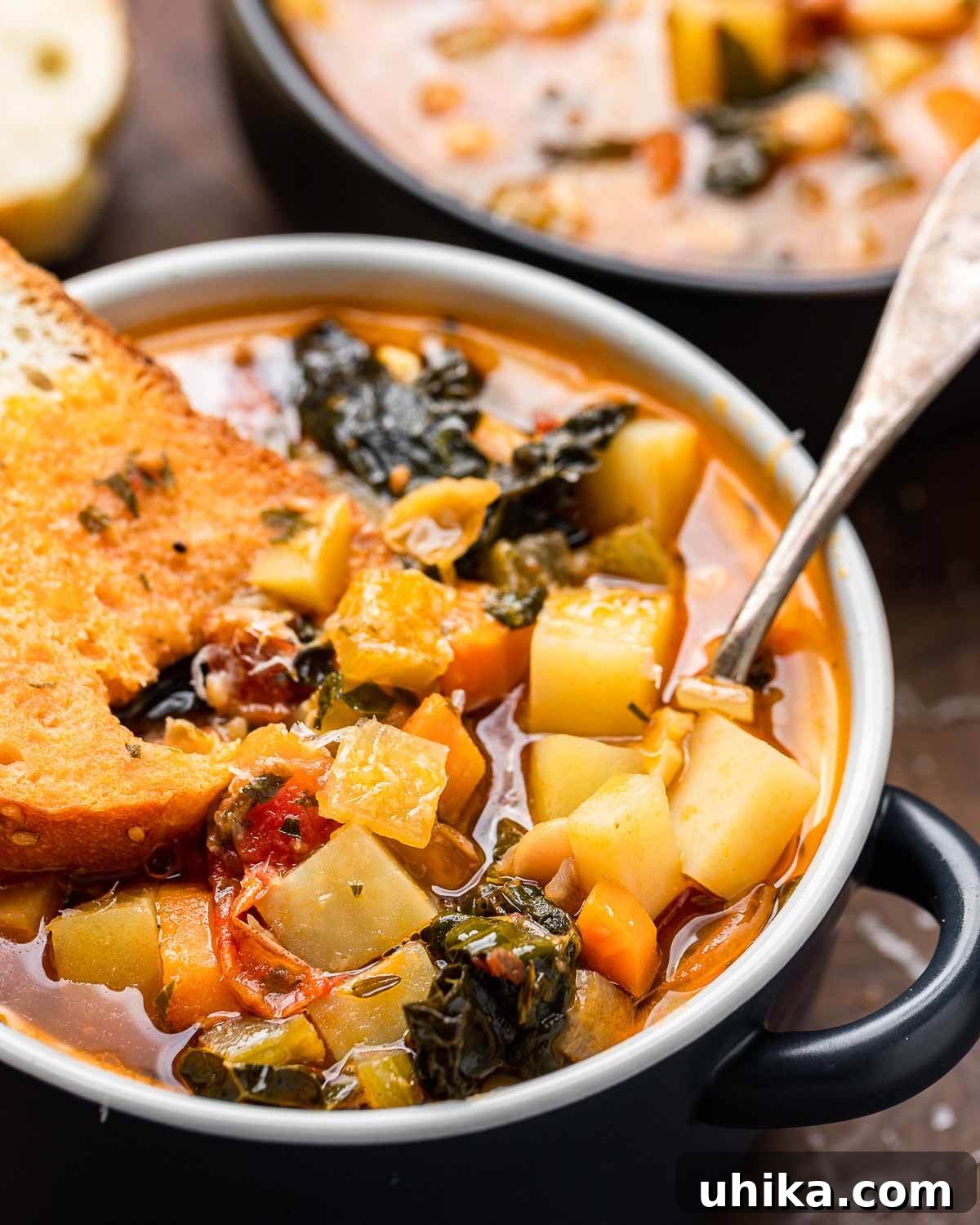 Hearty Vegetable Minestrone 8 Small bowl of minestrone soup with bread dipped into it.