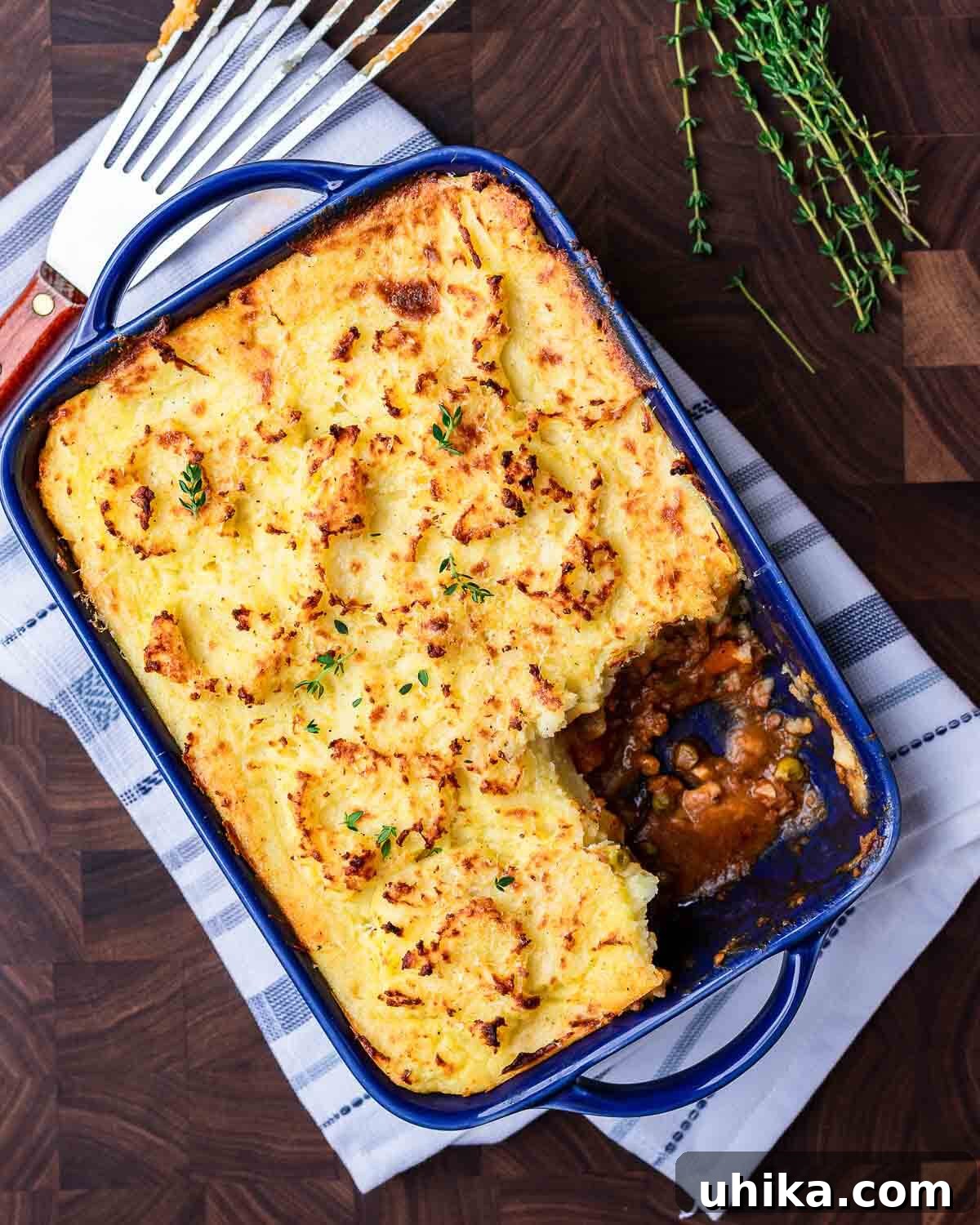 Homestyle Shepherds Pie 8 Ovehead shot of shepherd's pie in blue dish with one slice taken out of it.