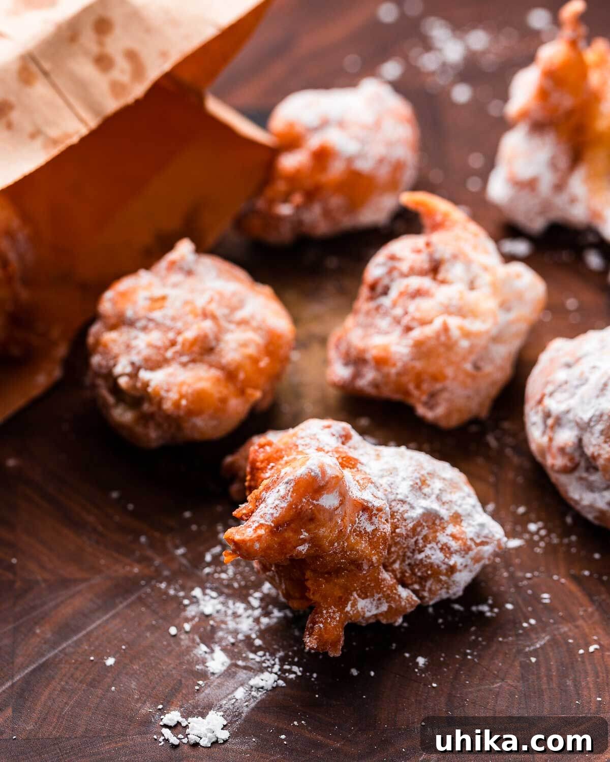 Italian Doughnut Delights 2 Zeppole on cutting board with brown paper bag.