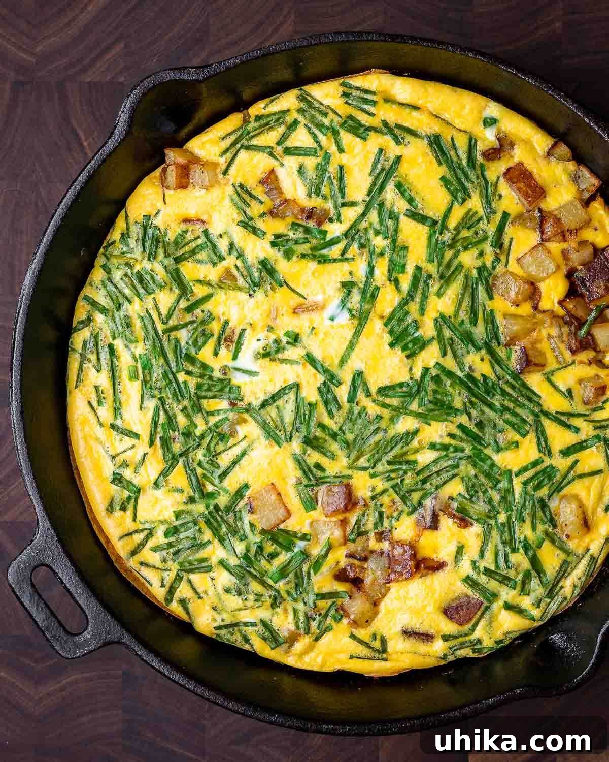 Rustic Potato and Egg Bake 9 An inviting overhead shot of a golden-brown potato frittata, fresh out of the oven, still sizzling in its cast iron pan, ready to be sliced and served.