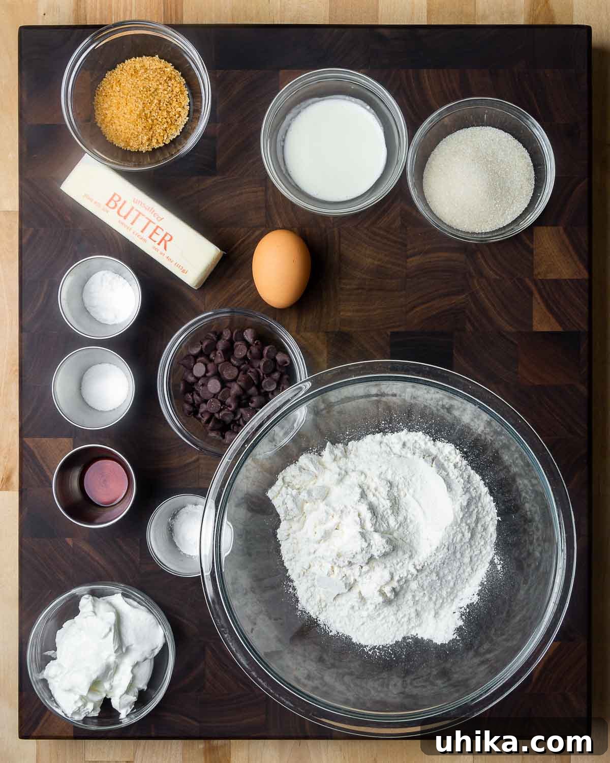 Decadent Chocolate Chip Scones 3 Ingredients shown: turbinado sugar, heavy cream, sugar, butter, 1 egg, baking powder and soda, chocolate chips, vanilla, salt, flour, and sour cream. All components for delicious chocolate chip scones.