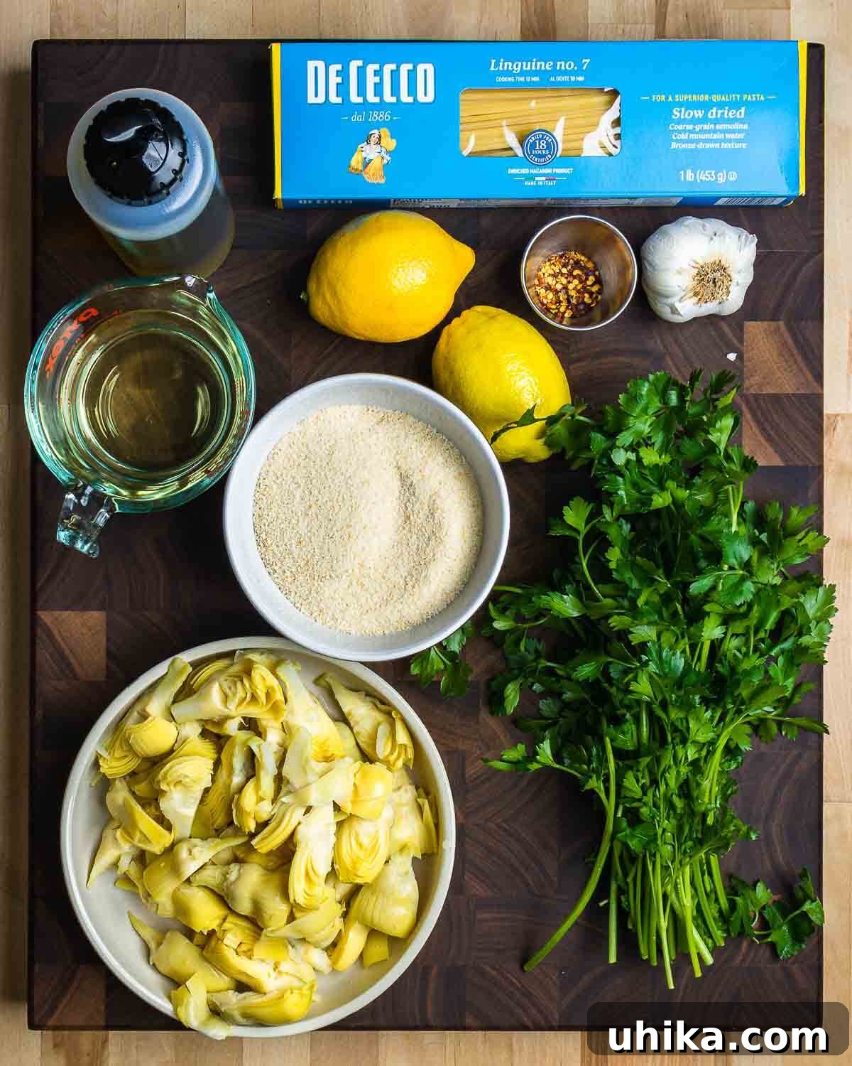 Golden Crumb Artichoke Pasta 3 Ingredients shown: linguine, olive oil, lemons, white wine, parsley, garlic, breadcrumbs, and artichoke hearts.