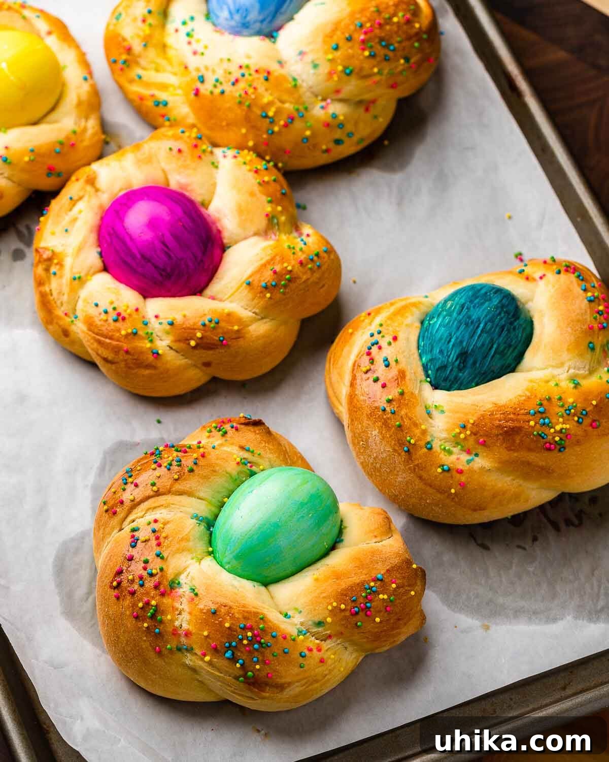 Italy's Festive Pasqua Bake 10 Parchment paper lined baking sheet with 5 Easter breads.