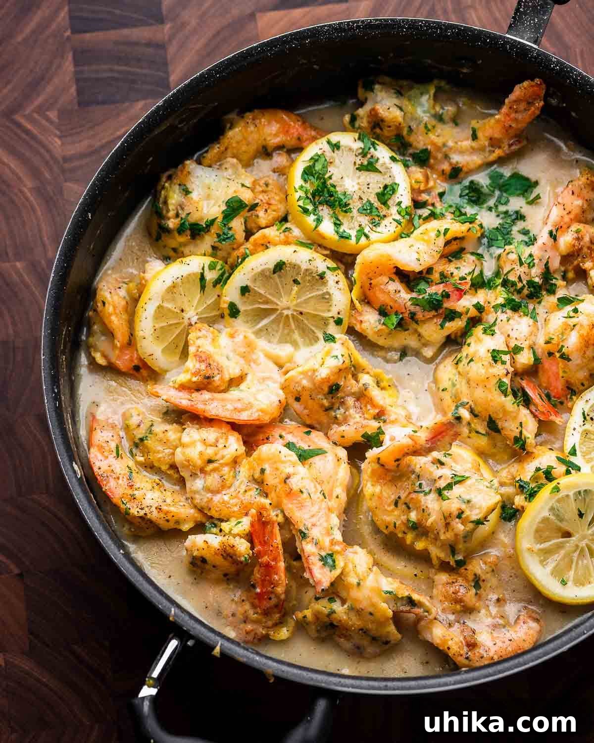 Golden Lemon Butter Shrimp 4 Overhead shot of black pan with shrimp francese, garnished with fresh parsley and lemon slices, ready to be served.