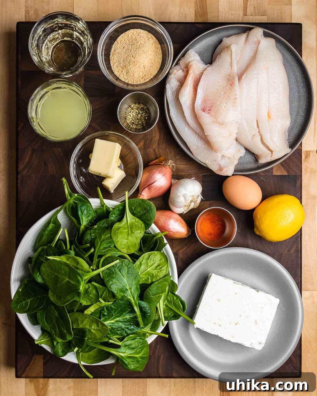 Savory Spinach Stuffed Flounder 3 Ingredients shown: white wine, chicken stock, breadcrumbs, oregano, flounder, butter, shallots, garlic, paprika, egg, lemon, baby spinach, and feta cheese.