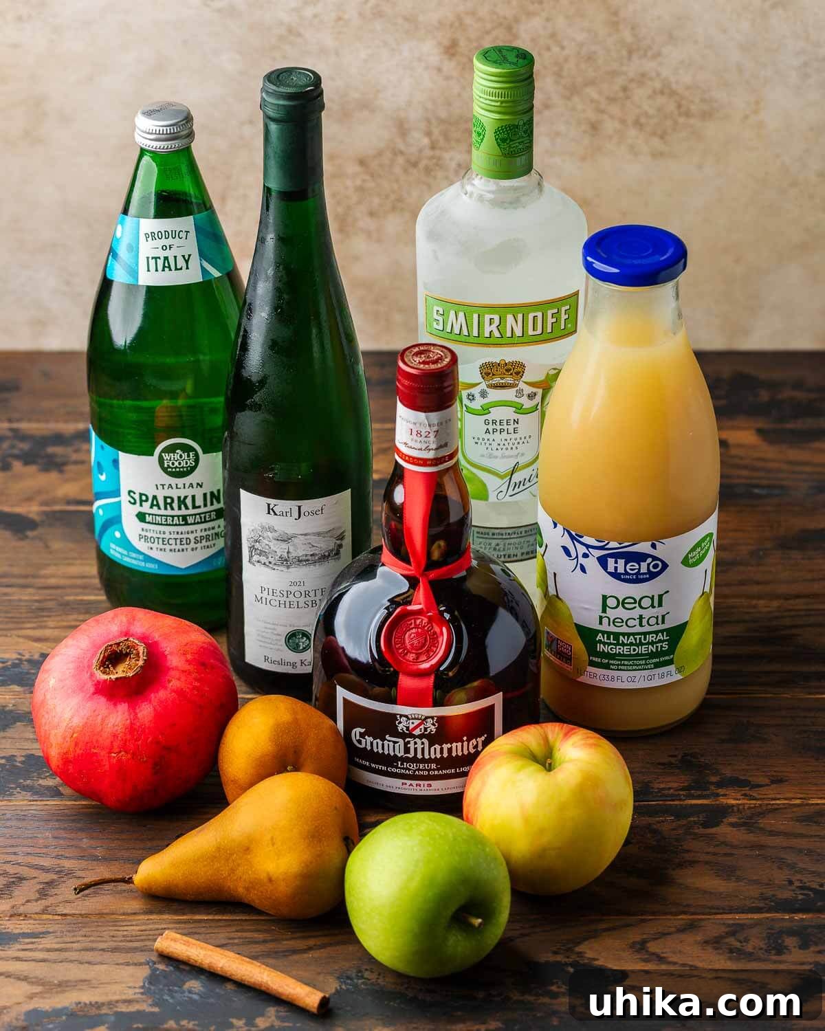 Spiced Autumn Sangria with Pears and Apples 3 All ingredients for white wine sangria laid out: sparkling water, Riesling wine, apple vodka, pear nectar, Grand Marnier, pomegranate, various pears and apples, and a cinnamon stick.