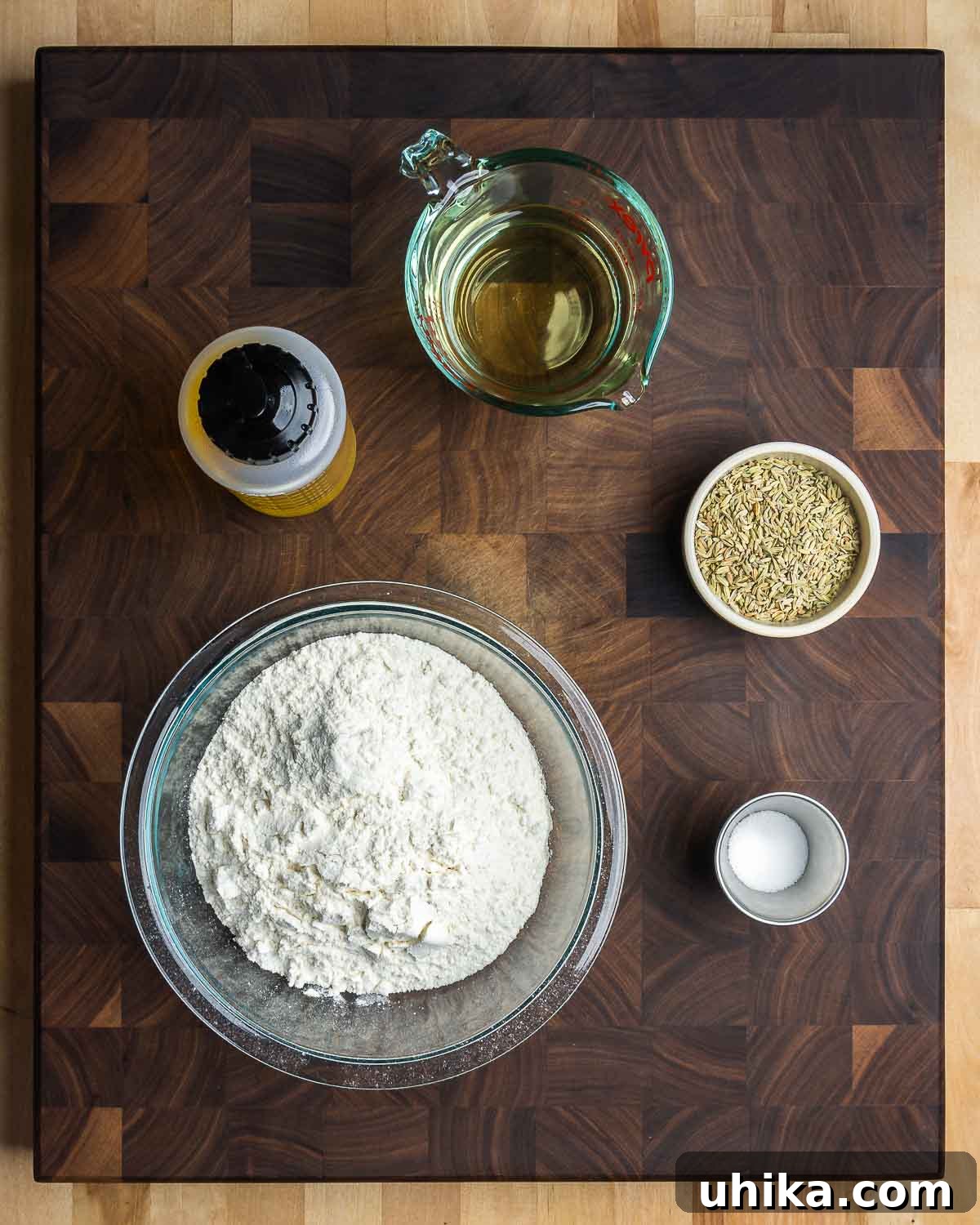 Taralli 3 Close-up shot of essential taralli ingredients laid out: olive oil, dry white wine, whole fennel seeds, all-purpose flour, and fine sea salt.