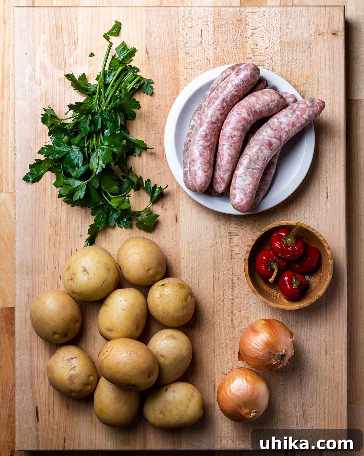 Rustic Italian Sausage and Potato Bake 3 Ingredients for Italian sausage and potatoes: parsley, Italian sausage links, potatoes, onions, and cherry peppers.