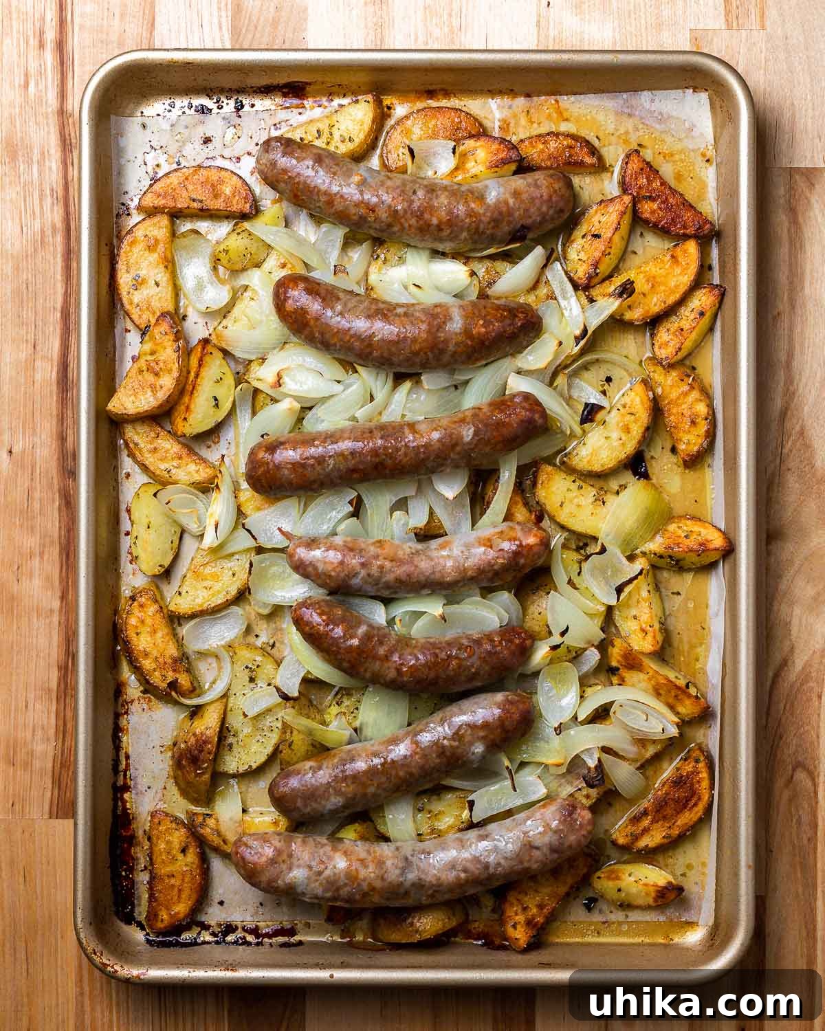 Rustic Italian Sausage and Potato Bake 7 Overhead photo of cooked Italian sausage and potatoes, garnished with parsley and cherry peppers.