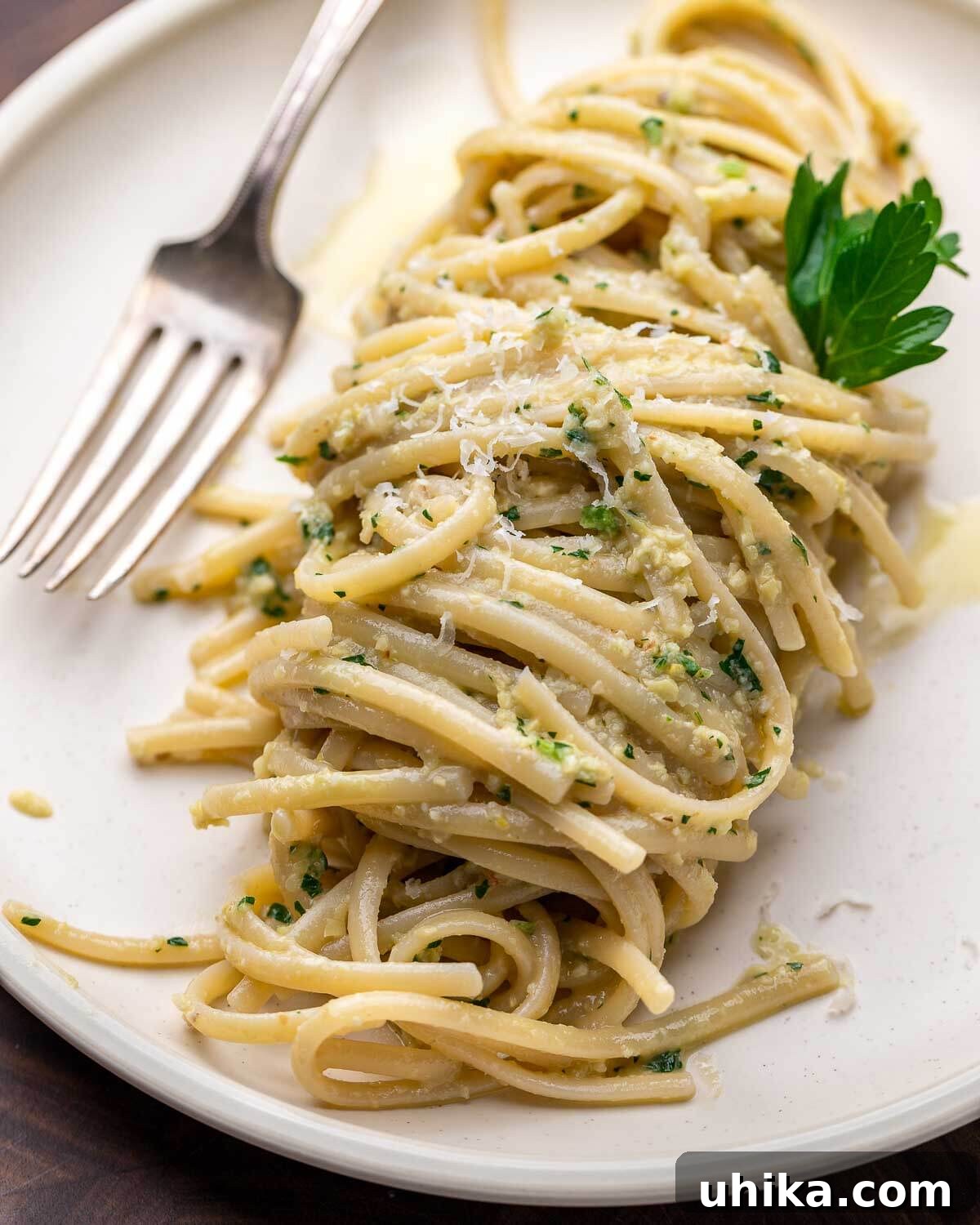 Vibrant Artichoke Pesto 2 Linguine with artichoke pesto in white plate, garnished with fresh parsley and a lemon slice.