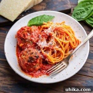A beautifully plated dish of spaghetti and meatballs, featuring tender meatballs nestled in rich tomato sauce alongside perfectly cooked pasta.
