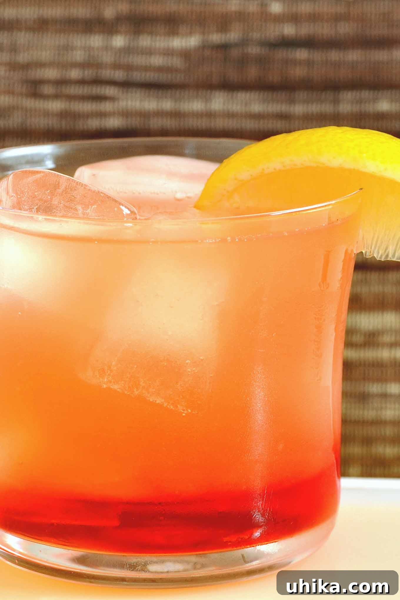 Sparkling Campari Limoncello Spritzer 2 A vibrant Campari Limoncello Spritzer cocktail, garnished with a fresh lemon slice, served in a tall glass filled with ice.
