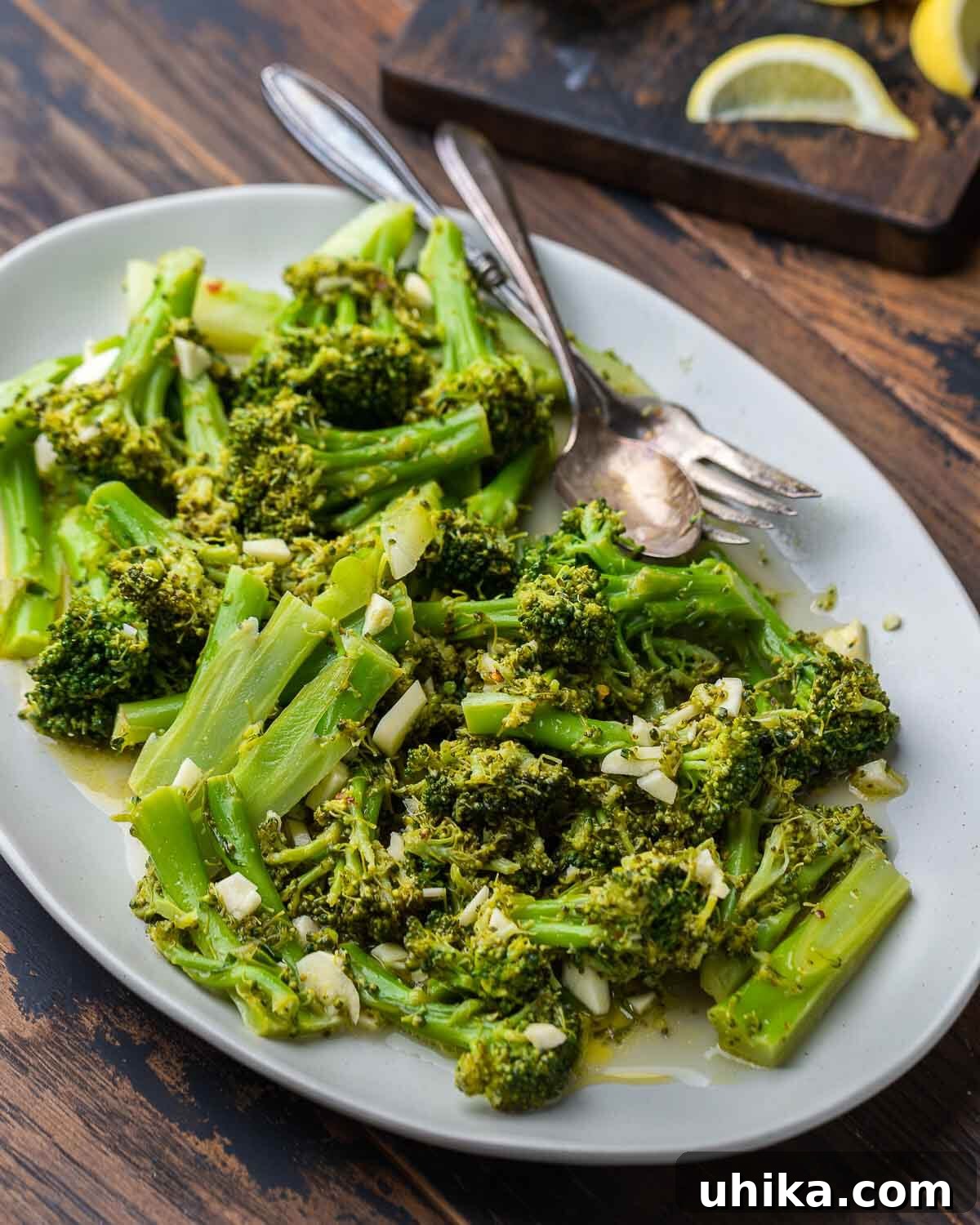 Vibrant Italian broccoli salad elegantly presented in a platter, with a fresh lemon wedge nestled in the background, suggesting its zesty flavor profile.