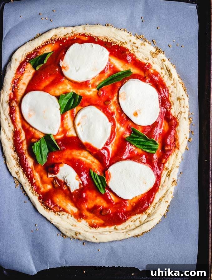 Assembling Margherita Pizza Margherita pizza assembled with garlicky tomato sauce, fresh mozzarella, and basil on store-bought dough.