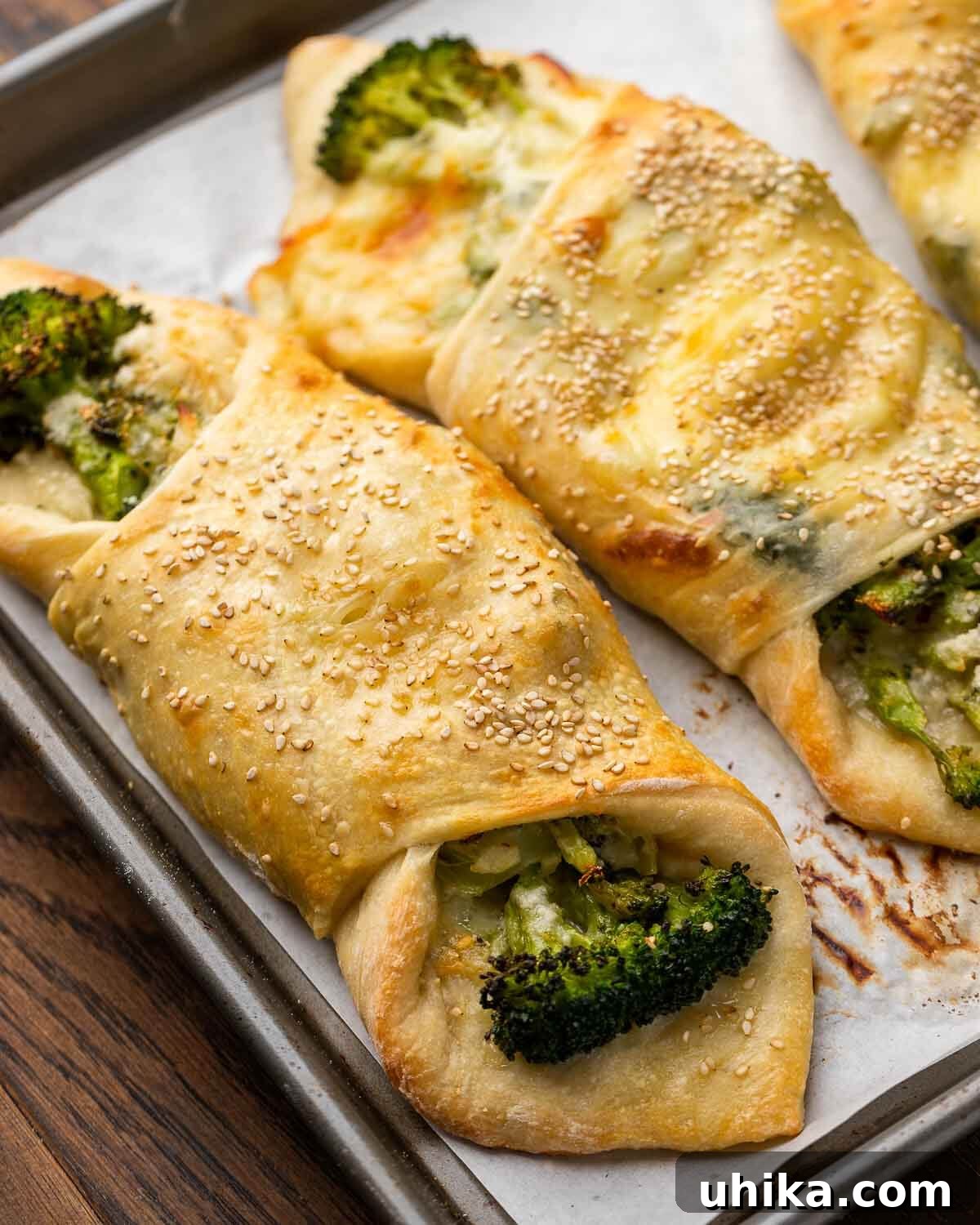 Broccoli Pinwheels 2 Closeup shot of golden-brown broccoli rolls in a sheet pan, ready to be served.