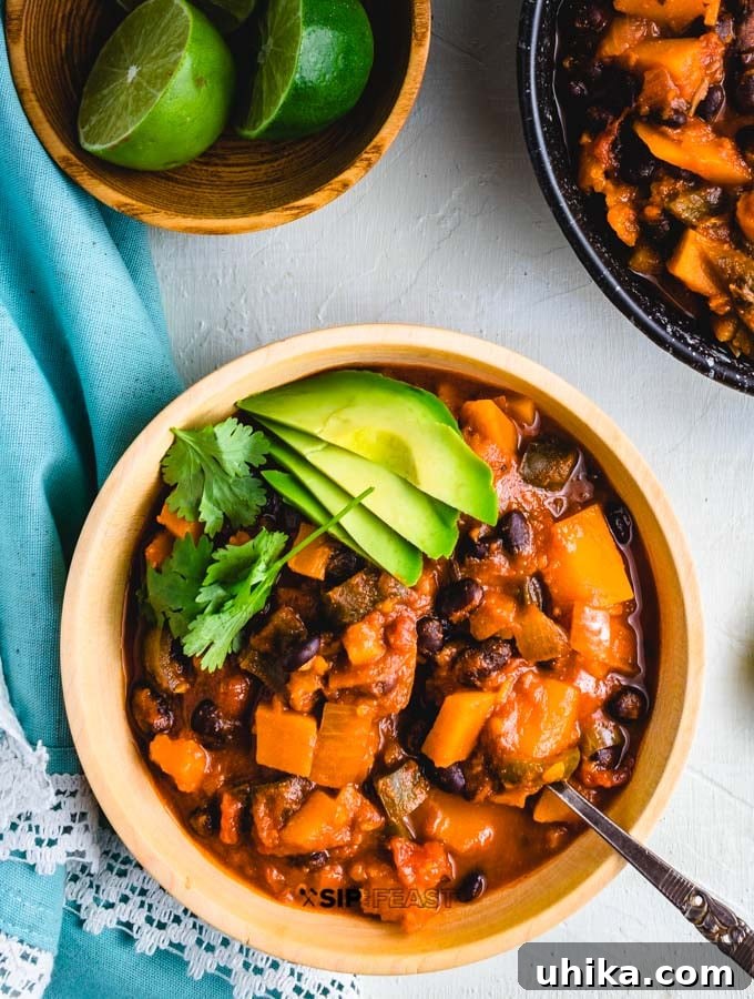 Roasted Poblano Peppers and Stewed Butternut Squash Chili - The Ultimate Fall Comfort Food Overhead shot of the chili with limes on the side.