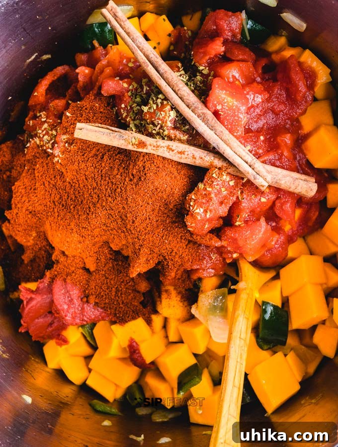 Roasted Poblano Peppers and Stewed Butternut Squash Chili - The Ultimate Fall Comfort Food Roasted poblano peppers with stewed butternut squash and spices in pot.