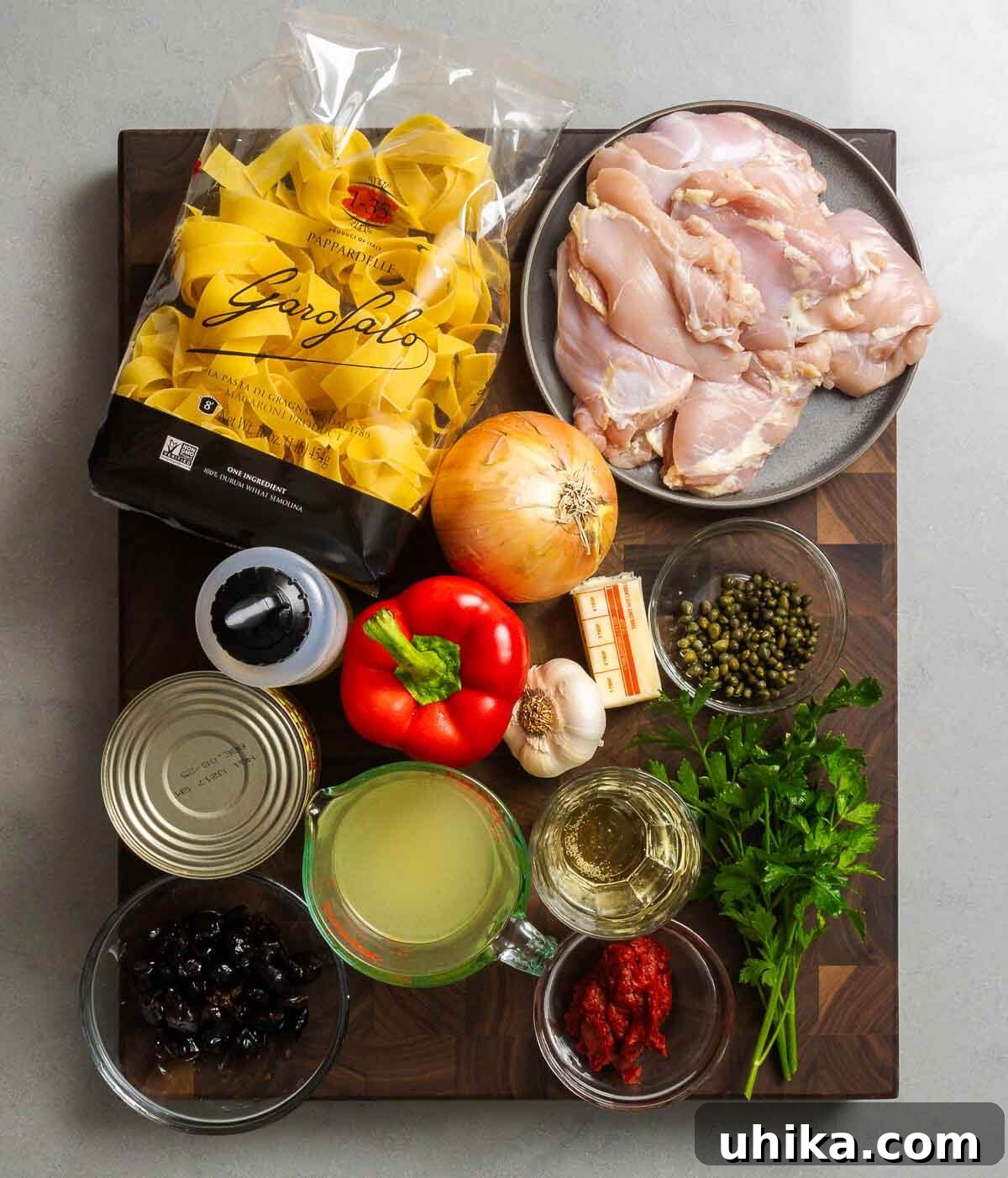 Rustic Chicken Cacciatore Pasta 3 Ingredients shown: pappardelle, chicken thighs, onion, olive oil, bell pepper, garlic, butter, capers, tomatoes, chicken stock, olives, white wine, tomato paste, and parsley.