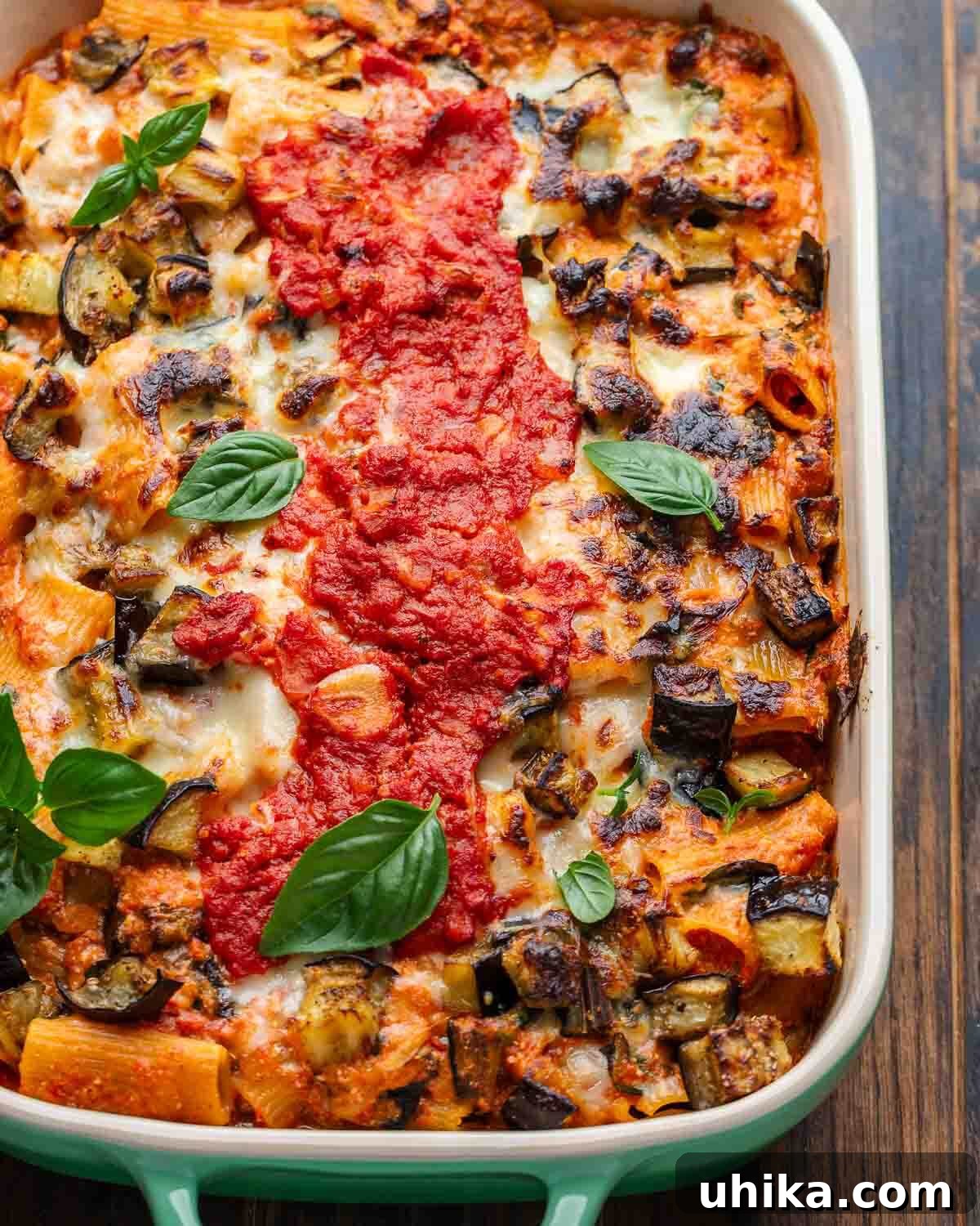Roasted Eggplant Pasta Bake 2 Overhead shot of baked eggplant pasta with basil leaves on top, served in a baking dish.