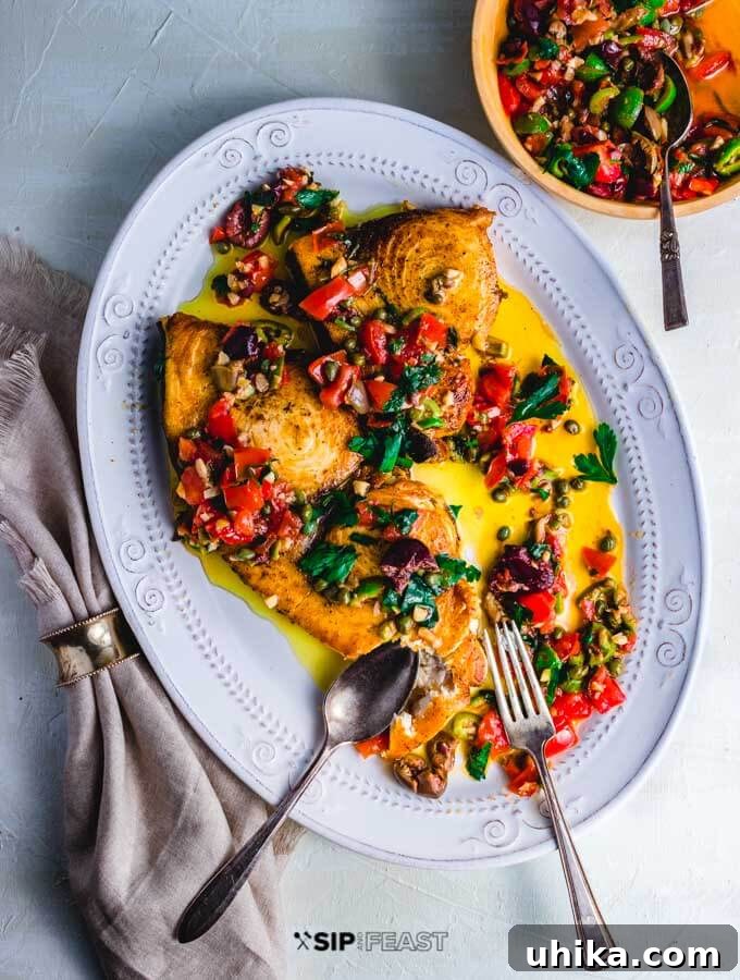 Pan Seared Swordfish with Olives and Capers - A Mediterranean Delight Beautifully pan-seared swordfish steaks adorned with a vibrant olive and caper sauce, ready to be served.
