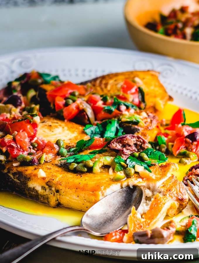 Pan Seared Swordfish with Olives and Capers Ready to Serve Close-up of a perfectly pan-seared swordfish steak with a rich olive and caper topping.