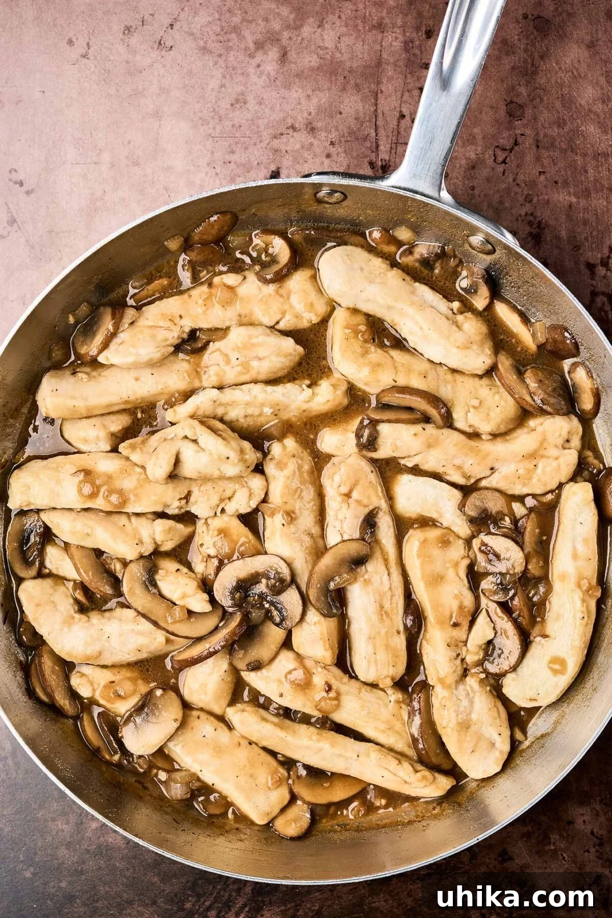 Creamy Marsala Chicken Pasta with Burst Tomatoes 5 A frying pan with chicken and mushrooms sautéed with garlic and onion in Marsala wine sauce.