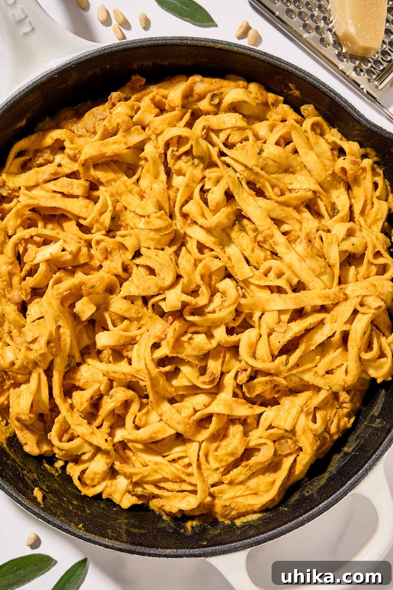 Golden Pumpkin Pasta with Crispy Pancetta and Creamy Parmesan 7 The last step for preparing creamy pumpkin pasta, fettuccine combined with pumpkin puree, pancetta, pine nuts, sage, and half and half.