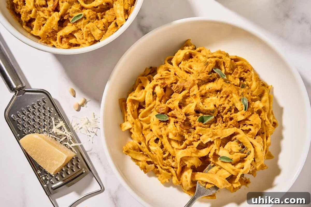 Golden Pumpkin Pasta with Crispy Pancetta and Creamy Parmesan 8 Homemade creamy pumpkin pasta in white bowls with crispy pancetta, sage, and toasted pine nuts, a cheese grater and chunk of Parmesan to the side.