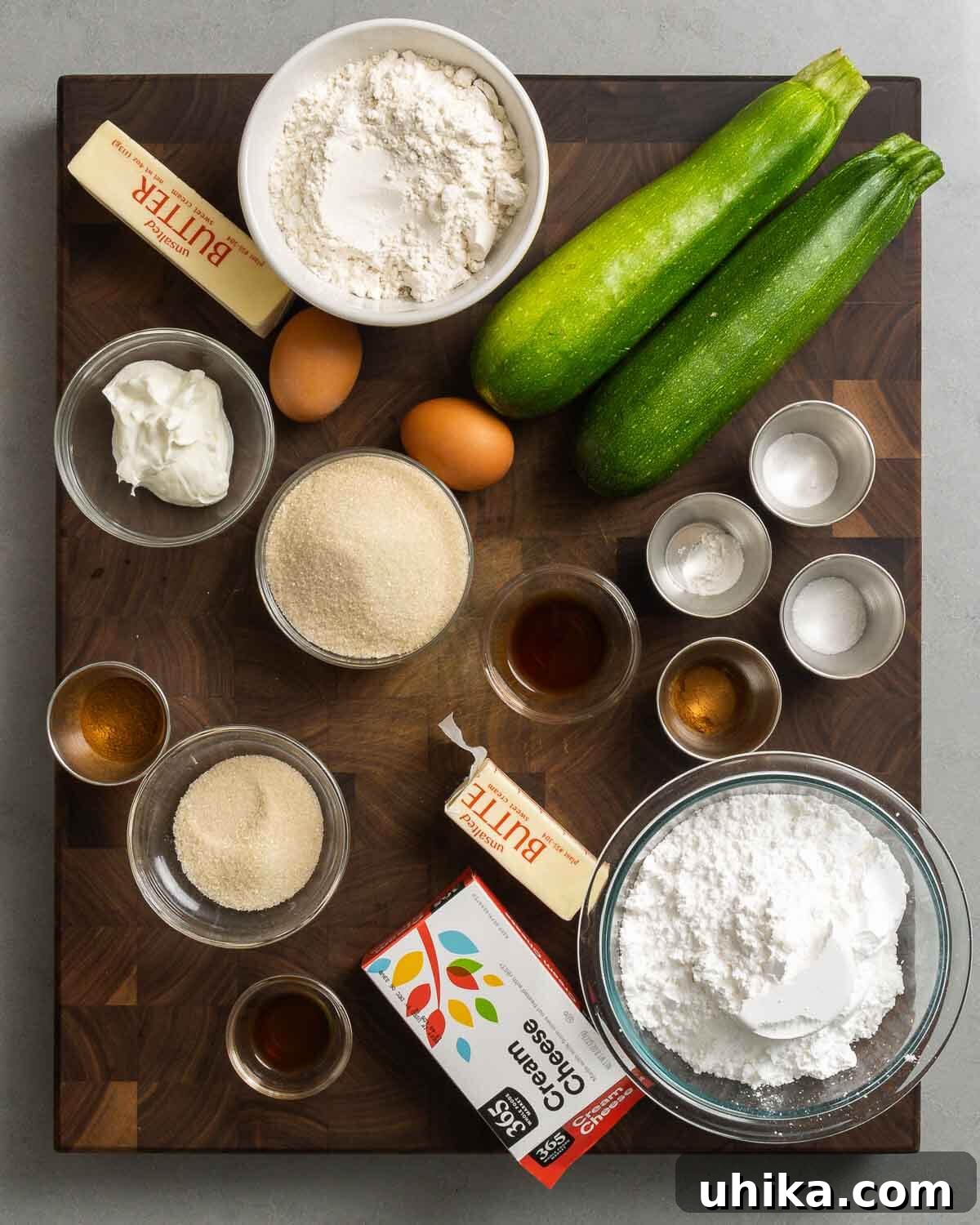 Moist Zucchini Loaf 3 A vibrant display of fresh ingredients for zucchini bread including butter, flour, zucchini, eggs, Greek yogurt, sugar, baking soda, baking powder, salt, cinnamon, and vanilla.