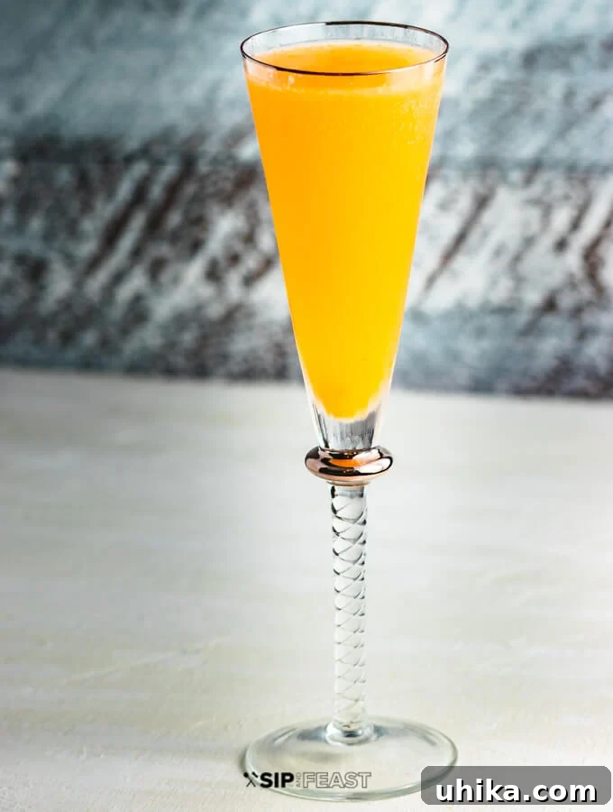 Finished Peach Bellini Cocktail The finished Next-Level Peach Bellini, a vibrant and inviting cocktail in a flute glass, garnished and ready to be enjoyed.