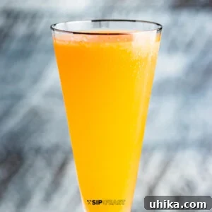 How to make a peach bellini featured image, showing the vibrant finished cocktail.